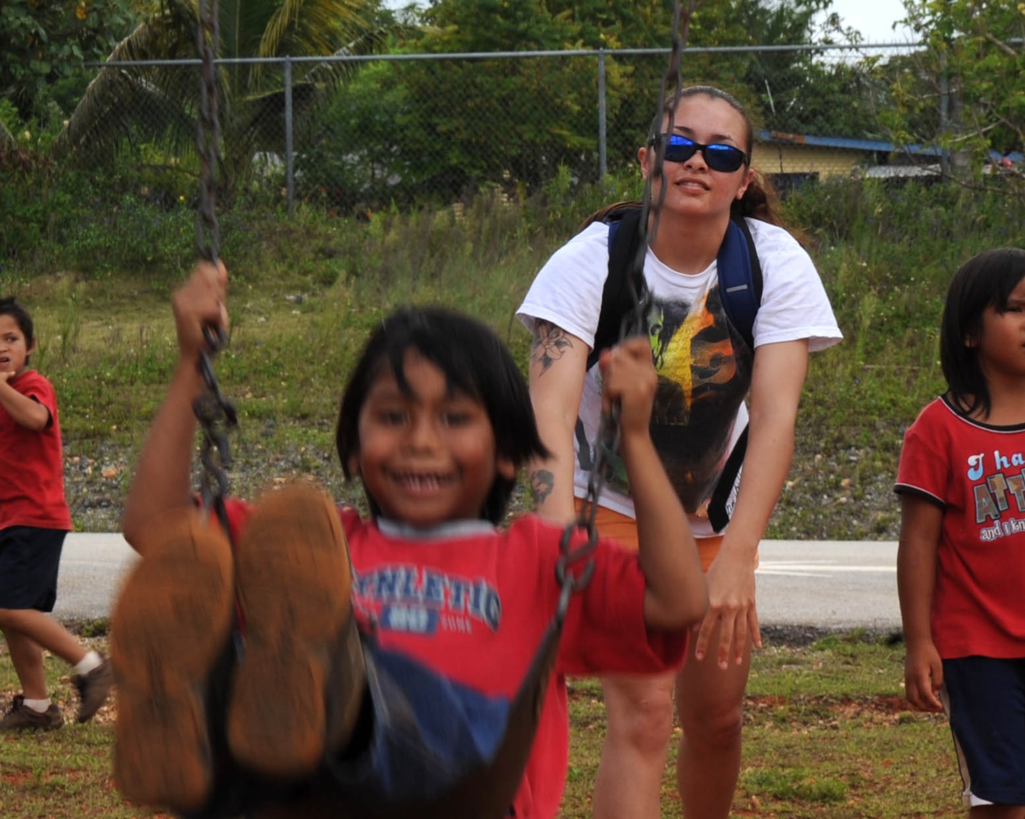 AGANA, Guam – Airman 1st Class Michelle E. Jaquith, 3rd Expeditionary Aircraft Maintenance Unit weapons load crew member, pushes a student on a swing set, on the playground at Machananao Elementary School. Airman Jaquith is a Summerville, S.C., native deployed to Andersen Air Force Base, Guam, from Elmendorf AFB, Alaska.  (U.S. Air Force photo by Senior Airman Christopher Bush)