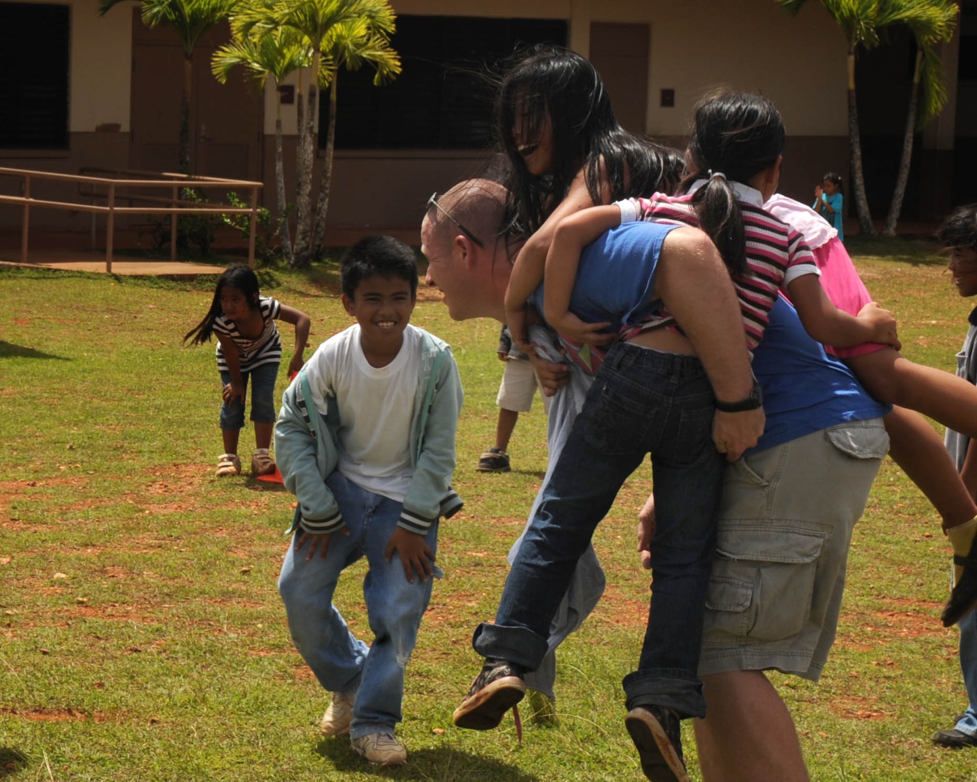 AGANA, Guam -- Staff Sgt. Jess B. Roach, 509th Expeditionary Aircraft Maintenance Unit weapons load crew member, plays with students during a kickball game at Machananao Elementary School.  The Fayetteville, Tenn., native is deployed here to Andersen Air Force Base, Guam, from Whiteman AFB, Mo.  (U.S. Air Force photo by Senior Airman Christopher Bush)