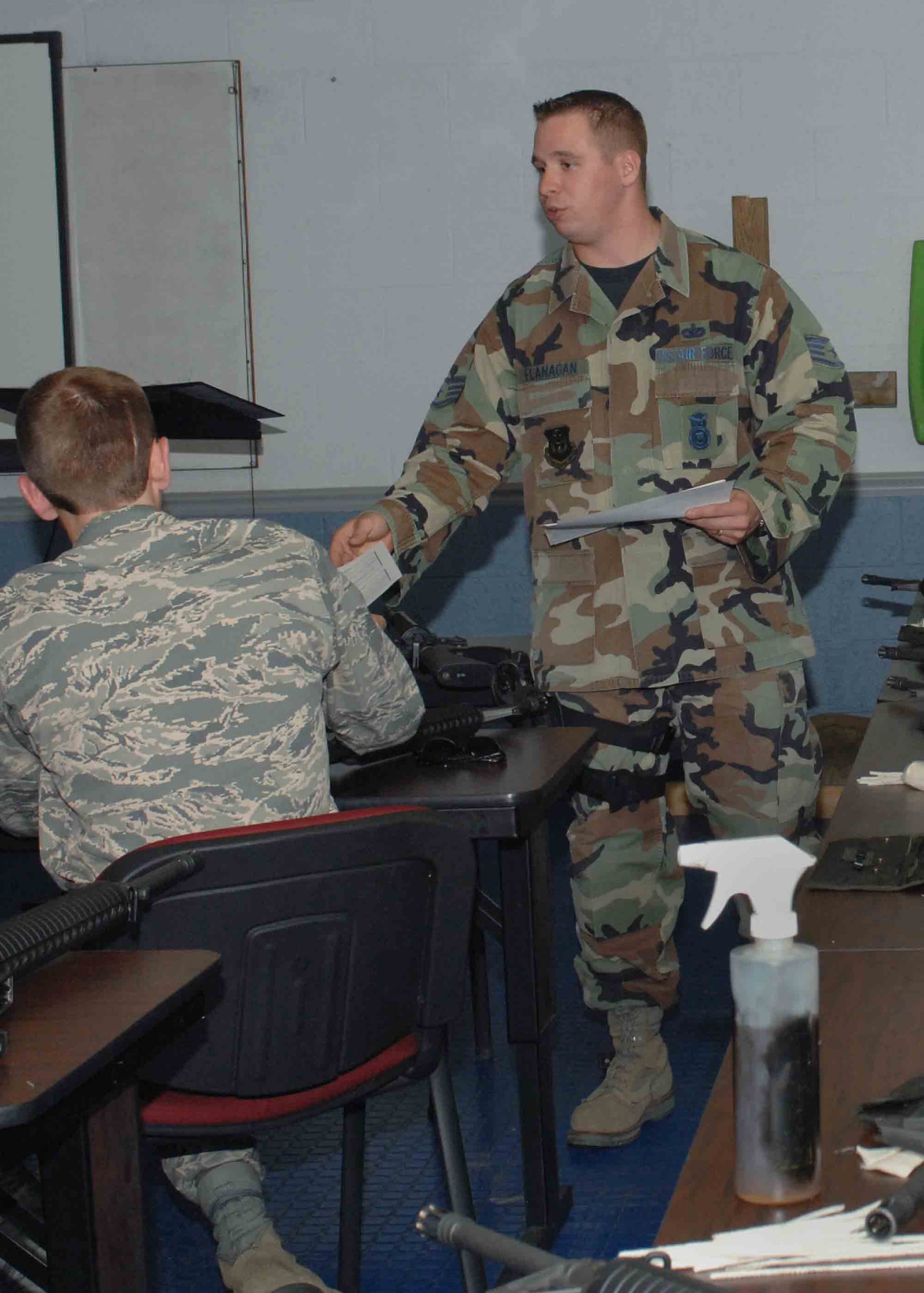 CANNON AIR FORCE BASE, N.M. -- Staff Sgt. Brian Flanagan, of the 27th Special Operations Security Forces Squadron, hands out registration sheets May 12 at the Excellence in Competition shooting match. Sergeant Flanagan briefed the second round of shooters about the tournament regulations and how to inspect their weapon before to shooting. (U.S. Air Force photo/Airman 1st Class James Bell) 