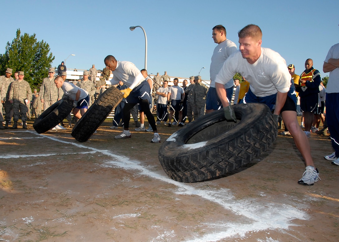 Contestants in the tire flip strain during their race to the championship.  Teams raced in relay fashion with four team members to be the first to flip their tire down the course in the event. The 82nd Training Wing had the fastest time in this event. (U.S. Air Force photo/ Mike Litteken)
