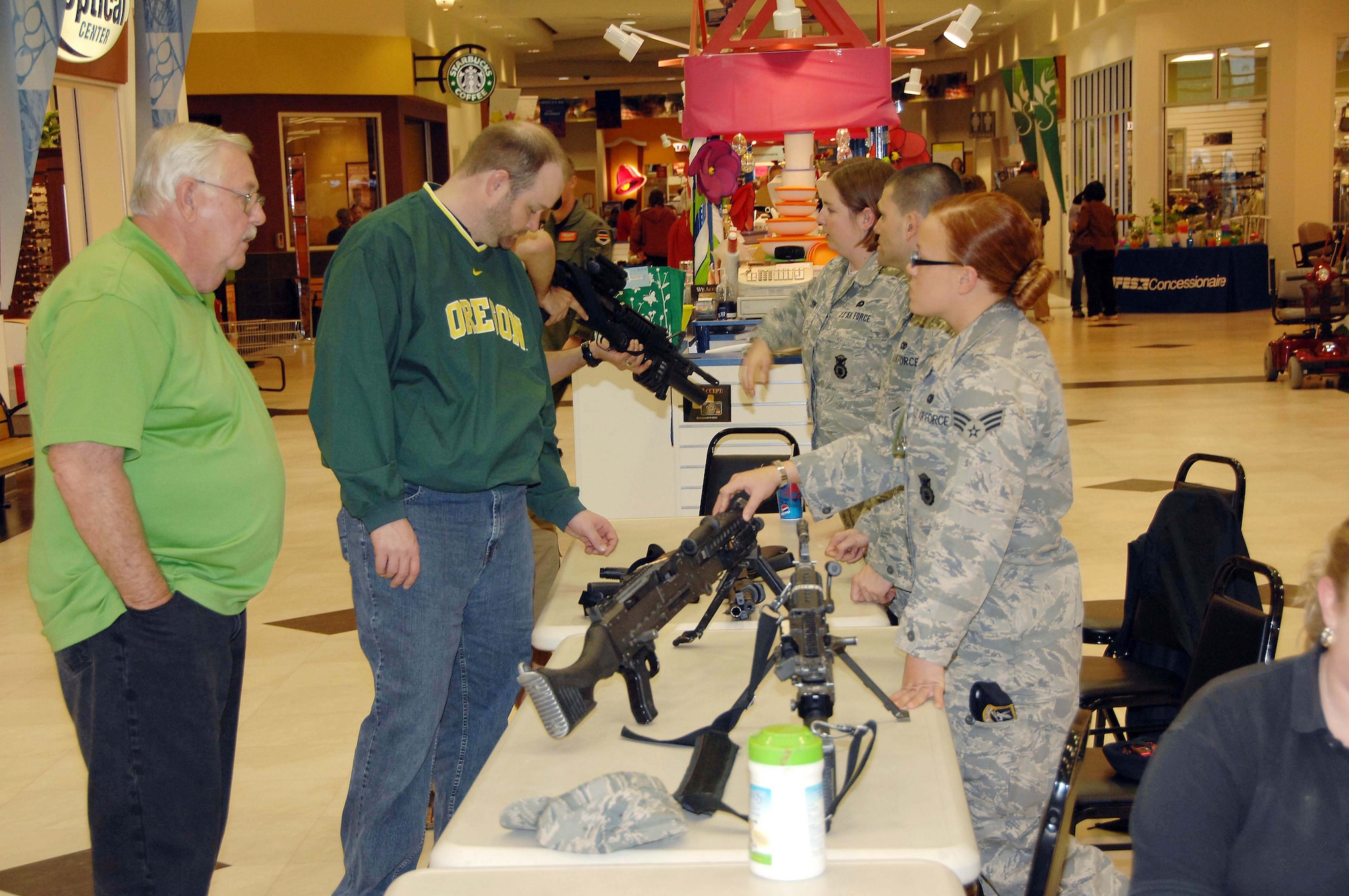 OFFUTT AIR FORCE BASE, Neb. - Members of the 55th Security Forces Squadron explain the operation of various weapons to members of the Offutt community during a military weapon display at the Base Exchange here May 15. The display was part of National Law Enforcement Week. U.S. Air Force Photo by Dana P. Heard