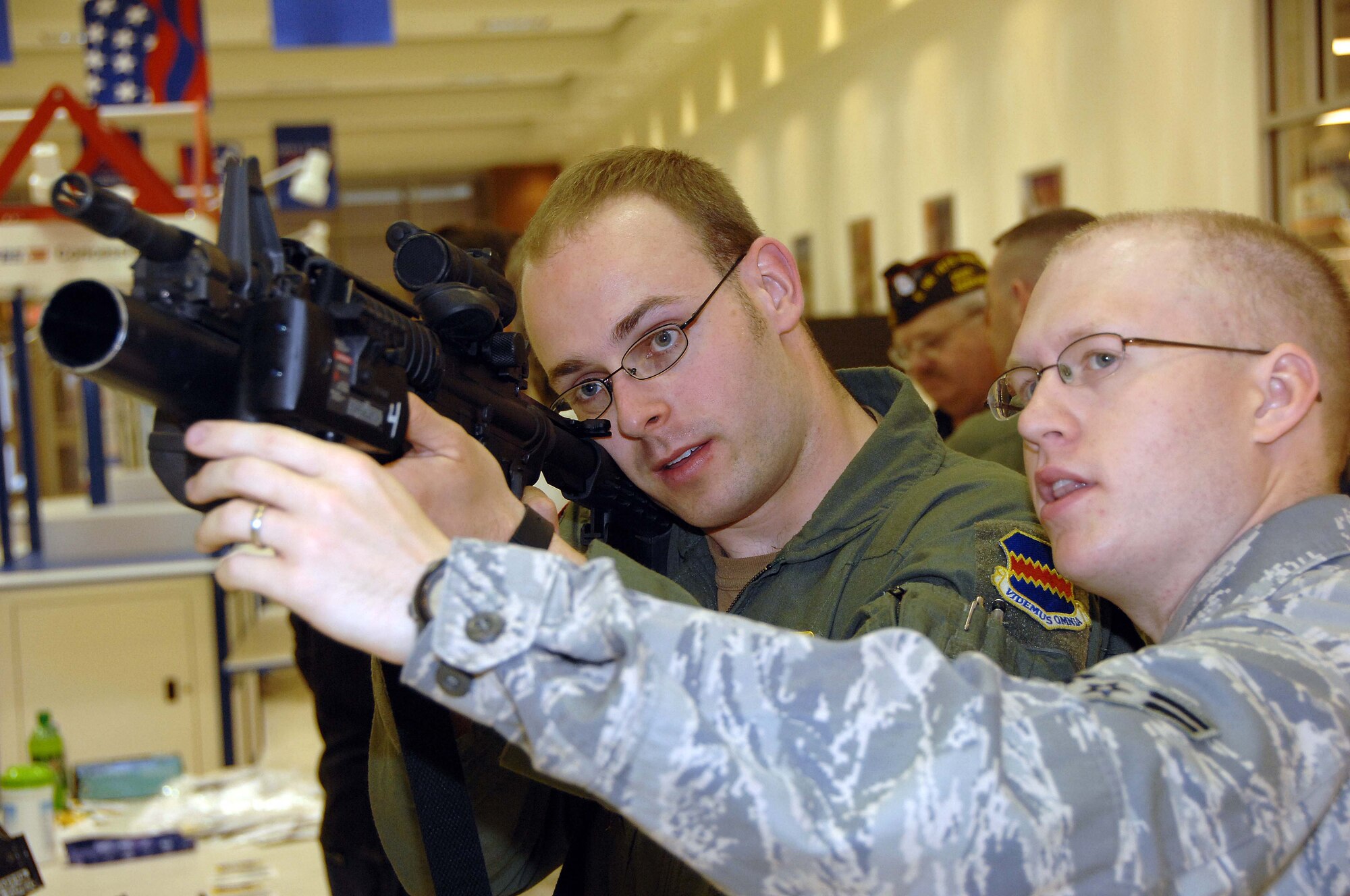 OFFUTT AIR FORCE BASE, Neb. - Airman 1st Class Trevor Crowder, an entry controller with the 55th Security Forces Squadron, explains the operation of the M-203 gernade launcher to Airman 1st Class, William J. Zipse, an airborne mission systems specialist with the 1st Airborne command and Control Squadron, during a military weapon display at the Base Exchange here May 15. The display was a part of National Law Enforcement Week. U.S. Air Force Photo by Dana P. Heard