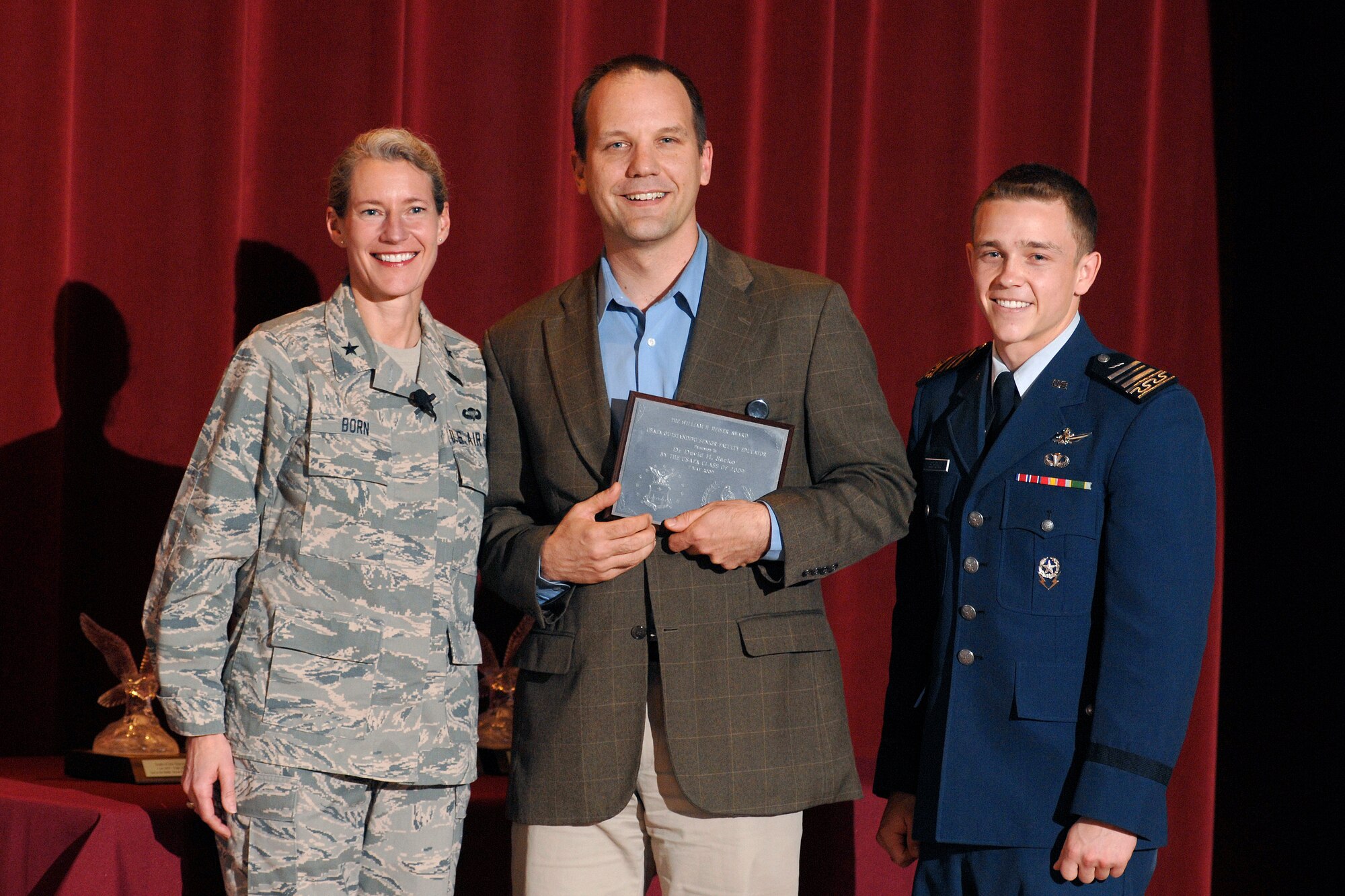 Dr. David Sacko, center, receives a 2009 Heiser Award from Brig. Gen. Dana Born, dean of the faculty, and Cadet 1st Class Jacob Schonig, Fall 2008 cadet wing commander, during an award presentation May 7. Each graduating class selects two senior faculty members from more than 160 eligible professors to receive the award. (U.S. Air Force photo/Dennis Rogers)