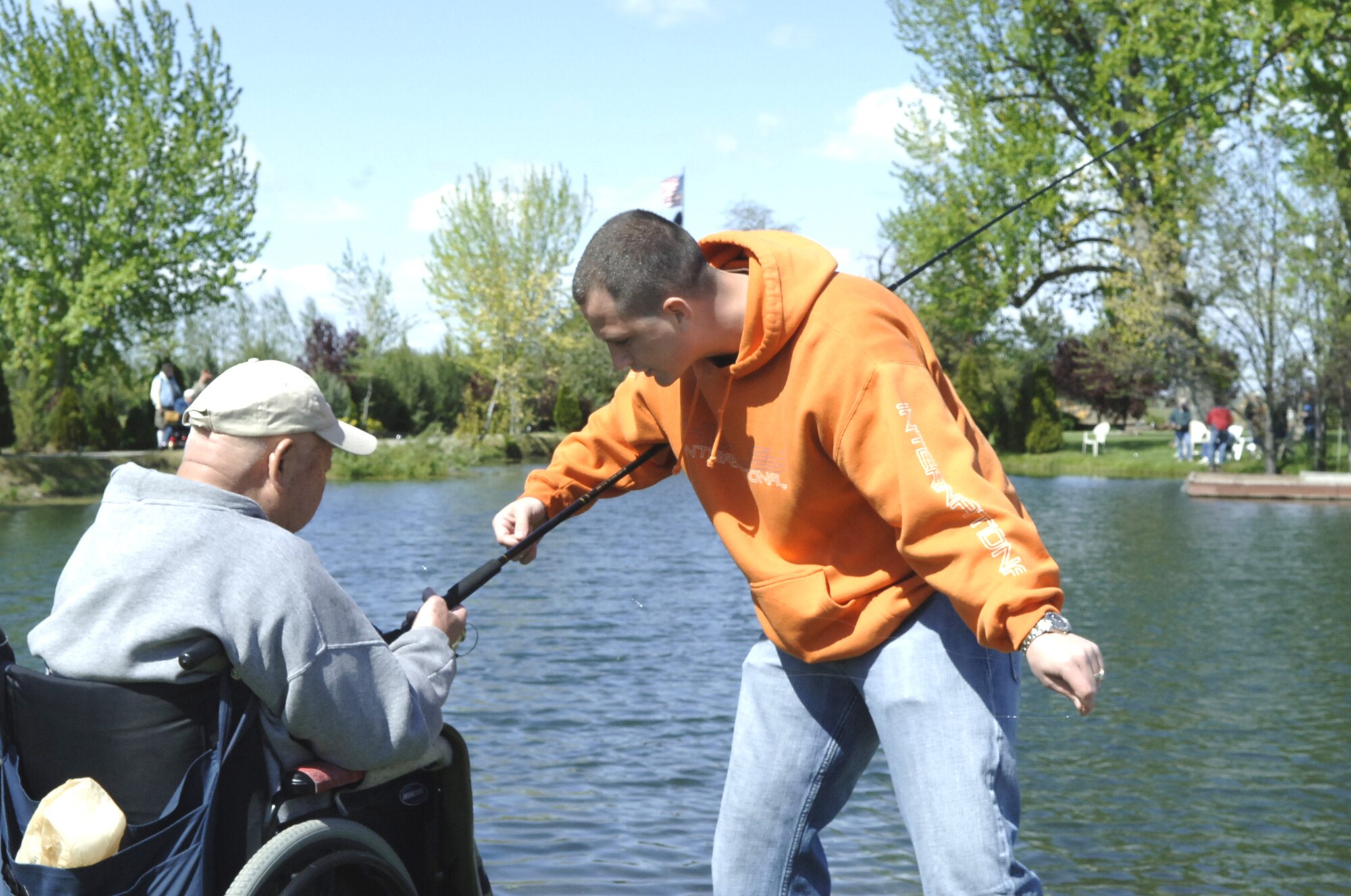 CALDWELL, Idaho – Tech. Sgt. William Rudd, 366th Fighter Wing Legal Office and FOCUS 56 activities coordinator, fishes with a veteran during the Idaho State Veterans Home Fishing Buddy Program May 12 in Caldwell, Idaho. More than 30 veterans ages 30 to 92 came out to fish with Airmen from Mountain Home AFB and Gowen Field, Boise, Idaho. (U.S. Air Force photo\Staff Sgt. Jasmine Reif)