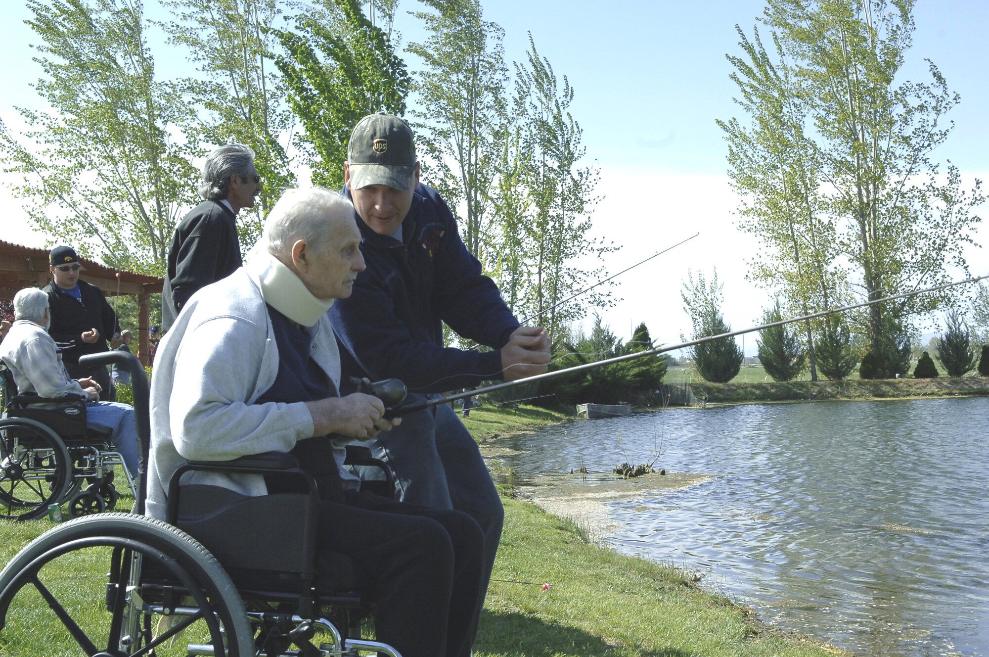 CALDWELL, Idaho - Staff Sgt. Trevor Stephens, 366th Civil Engineer Squadron, shows a veteran how to cast during the Idaho State Veterans Home Fishing Buddy Program May 12 in Caldwell, Idaho. More than 30 veterans ages 30 to 92 came out to fish with Airmen from Mountain Home AFB and Gowen Field, Boise, Idaho. (U.S. Air Force photo\Staff Sgt. Jasmine Reif)
