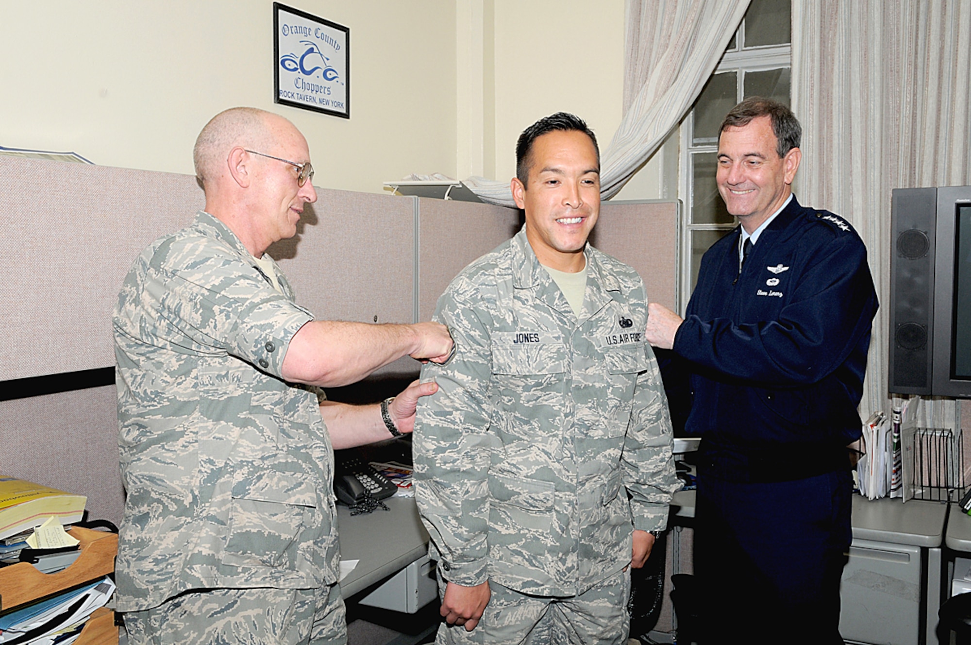 Staff Sgt. Rick Jones braces for a shot in the arm from Gen. Stephen Lorenz (right) and Col. Stan Chase during an impromptu Stripes to Exceptional Performers promotion ceremony March 25 at Randolph Air Force Base, Texas. As a special events NCO and manager of the Air Force NASCAR program, Sergeant Jones was selected for STEP promotion to technical sergeant for outstanding performance in his field. General Lorenz is the Air Education and Training Command commander and Colonel Chase retired as the vice commander for Air Force Recruiting Service, May 1. (U.S. Air Force photo) 