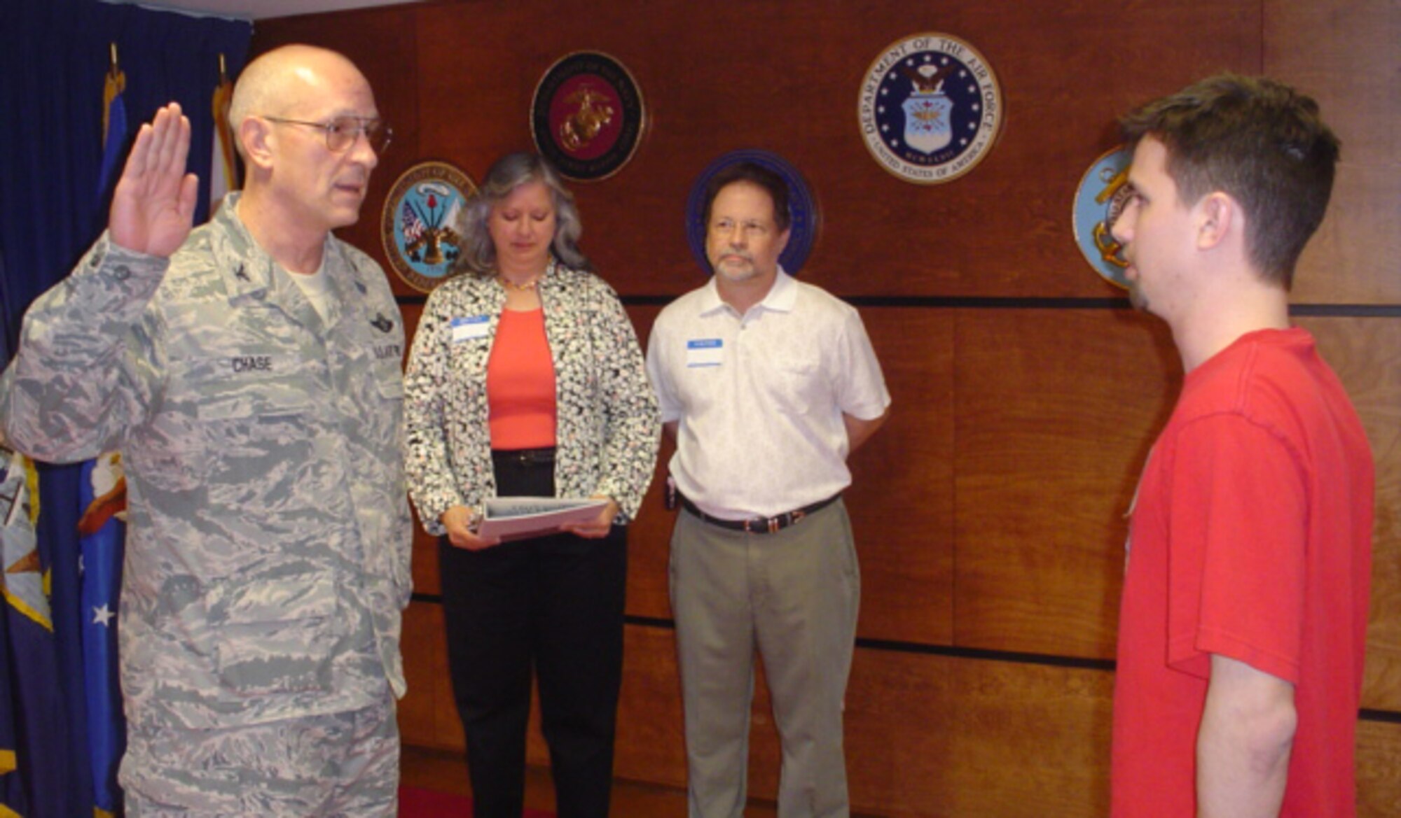 Col. Stan Chase administers the oath of enlistment to Ryan Scheeres recently at the Military Entrance Processing Station in Montgomery, Ala. Looking on are parents Roger and Junell Scheeres, both retired Air Force first sergeants. Colonel Chase retired as vice commander for Air Force Recruiting Service at Randolph Air Force Base, Texas, May 1. (U.S. Air Force photo/Staff Sgt. Adrian Bray) 
