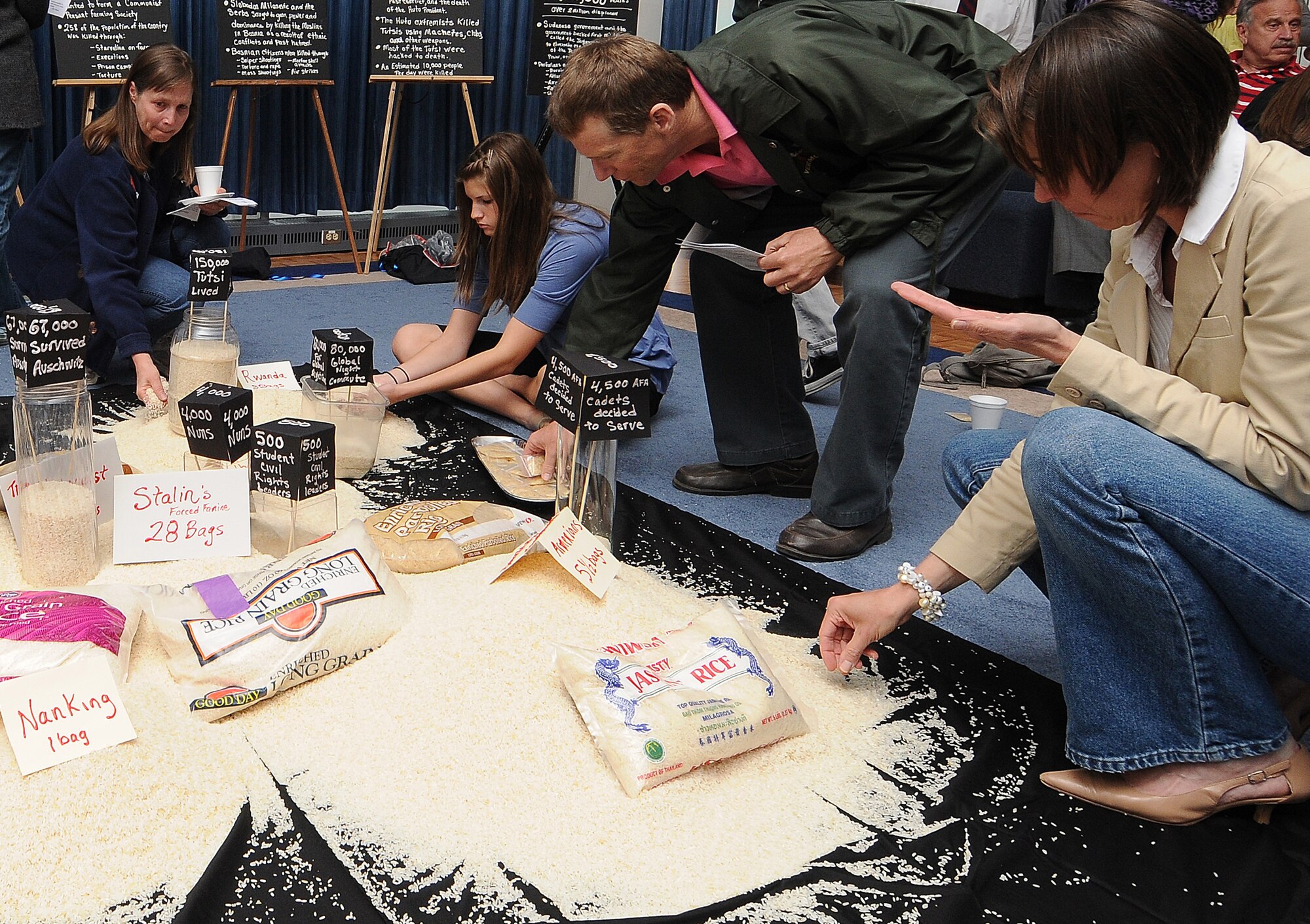 Members of the Air Force Academy community received a unique history lesson during a Holocaust remembrance gathering April 30 in the Arnold Hall Ballroom. The "rice project" included a teacher pouring rice into different piles on the floor; each pile represented a different genocide, and the grains of rice represented lives lost in each of the tragedies. (U.S. Air Force photo/Rachel Boettcher)