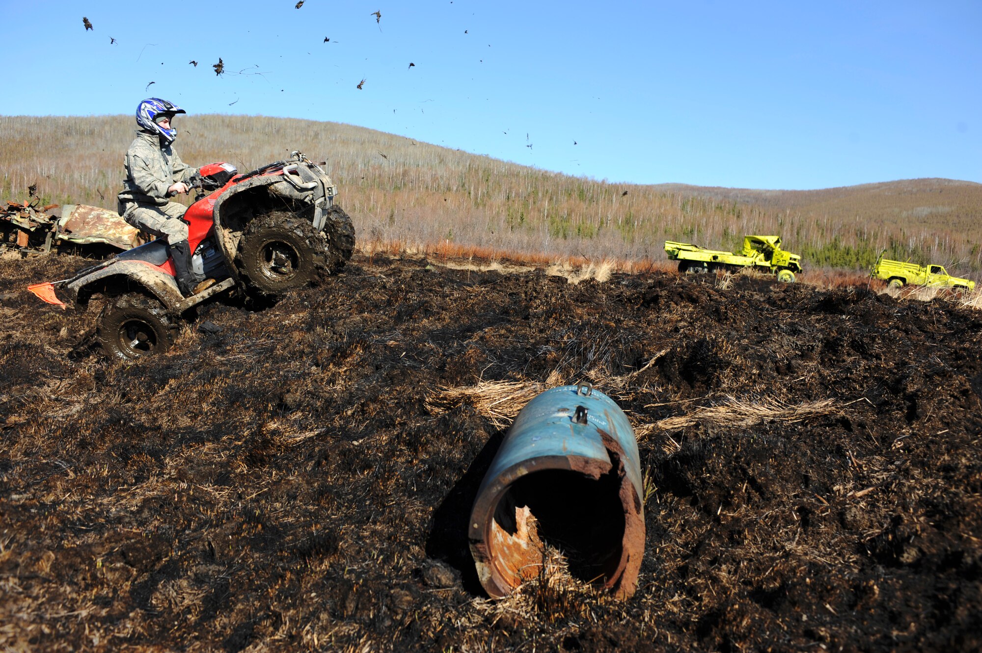 Airman 1st Class Brandon Wood uses an all-terrain vehicle to cover more ground in search of inert and live ordnance on the Yukon training area May 14, 2009, Eielson Air Force Base, Alaska. Explosive Ordnance Disposal Airmen and Marines clear 10,000 acres of land by walking within close proximity around each target while others use ATVs' to navigate the remaining terrain. Airman Wood is assigned to the 354th Civil Engineer Squadron EOD shop.  (U.S. Air Force Photo/Senior Airman Jonathan Snyder)