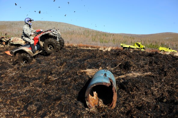 Airman 1st Class Brandon Wood uses an all-terrain vehicle to cover more ground in search of inert and live ordnance on the Yukon training area May 14 at Eielson Air Force Base, Alaska. Explosive Ordnance Disposal Airmen and Marines cleared 10,000 acres of land by walking within close proximity to each target while others used ATVs' to navigate the remaining terrain. Airman Wood is assigned to the 354th Civil Engineer Squadron EOD shop. (U.S. Air Force Photo/Senior Airman Jonathan Snyder) 
