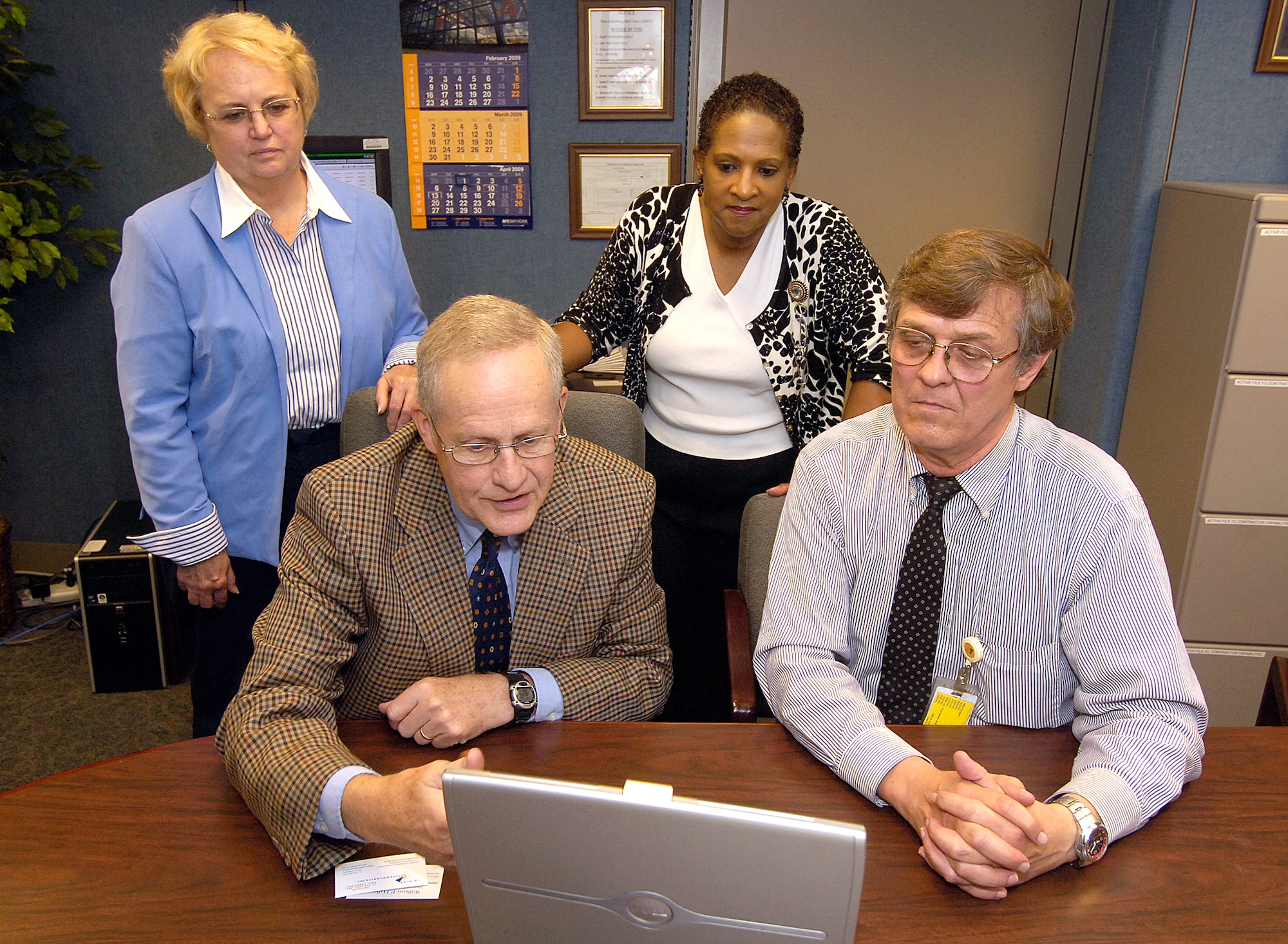 Carole Wanish, small business specialist, and Joanne Davis, Small Business Office director, look on as retired Lt. Gen. Bill Hallin, the executive consultant for Joining Technologies Inc., in East Granby, Conn., speaks with Joe Roop, source development specialist about opportunities at Tinker. (Air Force photo/Margo Wright)