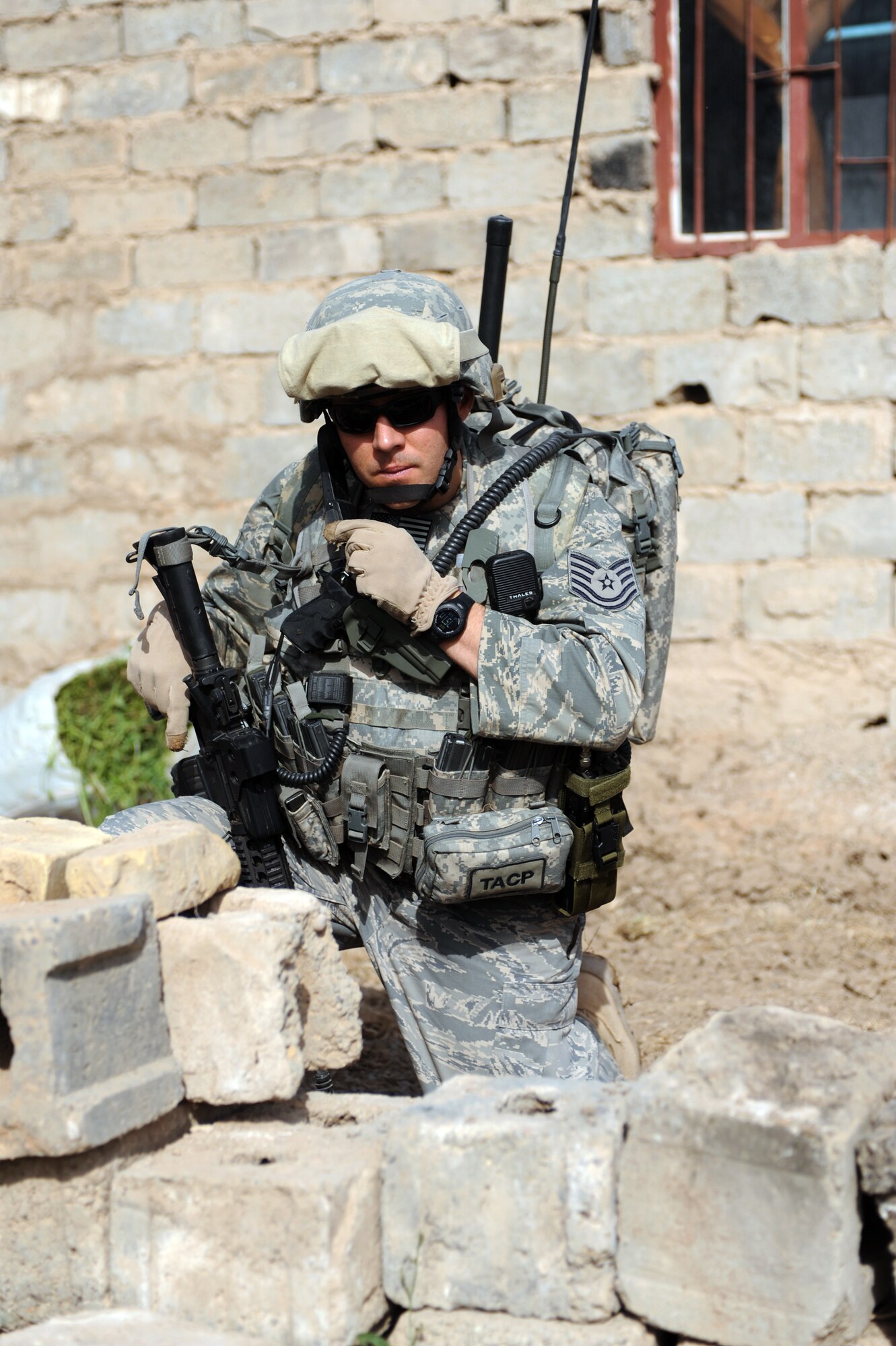 U.S. Air Force Tech Sgt. Beiuterman Jenkins attached to 2Tech. Sgt. Beiuterman Jenkins communicates his location after a weapons and munitions search in the neighborhood of Abu Nassir in Abu Ghraib, Iraq, May 13. U.S. Forces along with the Iraqi army work together in a combined effort to track down and arrest Iraqi Insurgents operating in the Abu Ghraib province of Iraq. Sergeant Jenkins is attached to 2nd Brigade, 1st Infantry Division. (U.S. Navy photo/Mass Communication Specialist 2nd Class Robert Whelan)