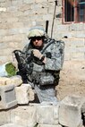 U.S. Air Force Tech Sgt. Beiuterman Jenkins attached to 2Tech. Sgt. Beiuterman Jenkins communicates his location after a weapons and munitions search in the neighborhood of Abu Nassir in Abu Ghraib, Iraq, May 13. U.S. Forces along with the Iraqi army work together in a combined effort to track down and arrest Iraqi Insurgents operating in the Abu Ghraib province of Iraq. Sergeant Jenkins is attached to 2nd Brigade, 1st Infantry Division. (U.S. Navy photo/Mass Communication Specialist 2nd Class Robert Whelan)