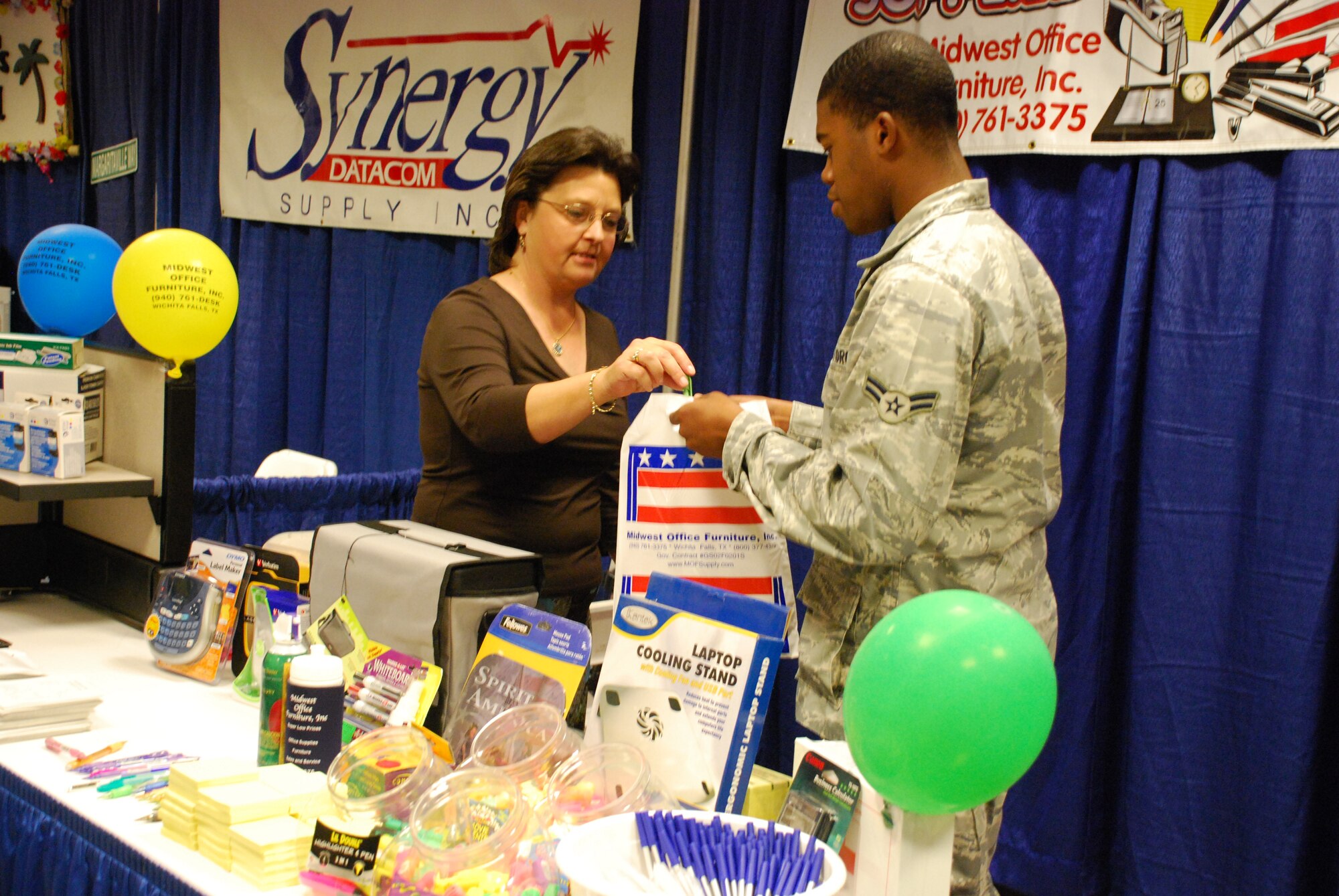 Tammie Martin, a military sales consultant for Midwest Office Furniture, Inc., discusses some of the business’ products with Airman 1st Class Andru Jones, a Government Purchase Card holder for the 882nd Training Support Squadron, at the Midwestern State University Clark Student Center May 19. More than 45 vendors attended. (U.S. Air Force photo/Airman 1st Class Valerie Hosea)