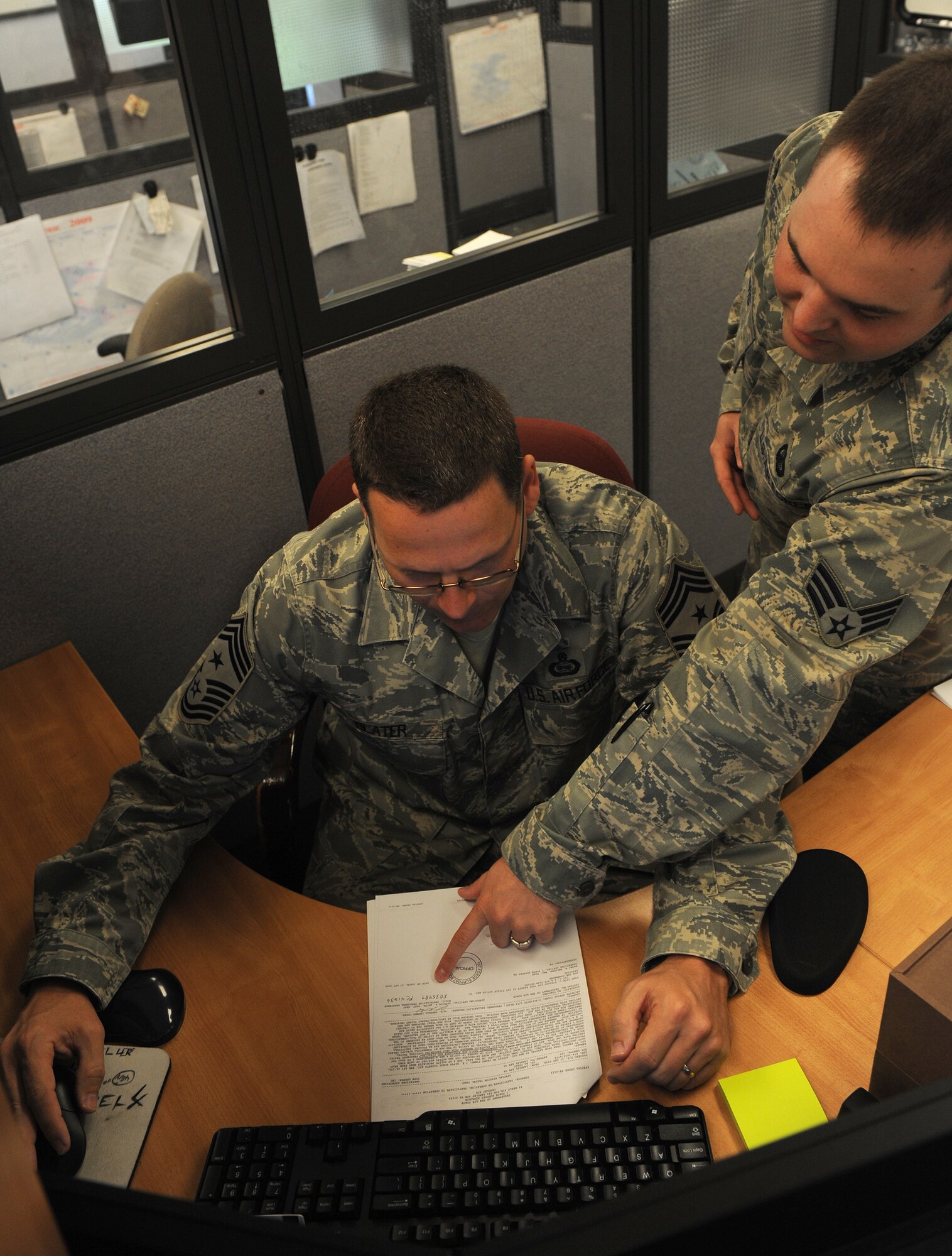 LANGLEY AIR FORCE BASE, Va. -- Senior Airman Jonathan Davis, 1st Comptroller Squadron lead customer service technician, shows Command Chief Master Sgt. Kevin Slater how to input a travel voucher May 19.  Chief Slater spent the morning working side-by-side with Airman from the 1st Comptroller Squadron.  (U.S. Air Force photo/Airman 1st Class Zachary Wolf)