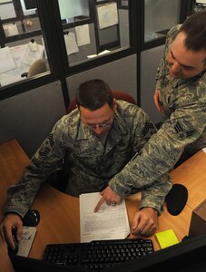 LANGLEY AIR FORCE BASE, Va. -- Senior Airman Jonathan Davis, 1st Comptroller Squadron lead customer service technician, shows Command Chief Master Sgt. Kevin Slater how to input a travel voucher May 19.  Chief Slater spent the morning working side-by-side with Airman from the 1st Comptroller Squadron.  (U.S. Air Force photo/Airman 1st Class Zachary Wolf)