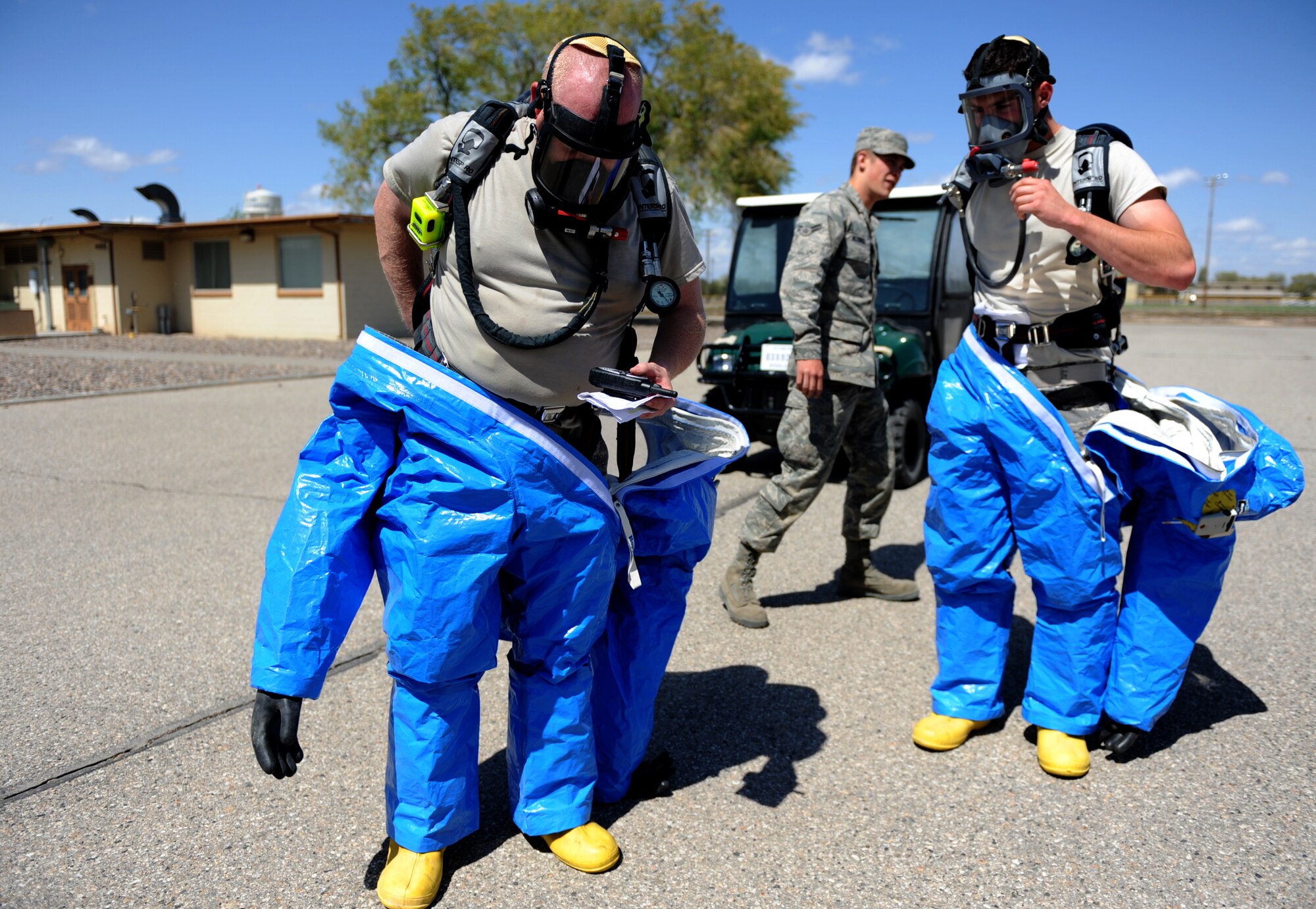 MOUNTAIN HOME AIR FORCE BASE, Idaho -- Tech. Sgt. Kiley Davis and Airman 1st Class Todd Kolva, 366th Aerospace Medicine Squadron bioenvironmental engineer technician, remove their hazardous chemical protective suits after their air ran out while in the contaminated building May 12. The bioenvironmental engineer flight is participating in the Air Combat Command chemical, biological, radiological, nuclear and high yield explosive (CBRNE) challenge, which consists of several scenarios they may encounter such as a suspicious package or a chemical spill. The team will compete against other ACC bases and could then move on to compete at the Air Force level. (U.S. Air Force photo/ Senior Airman Ryan Crane)