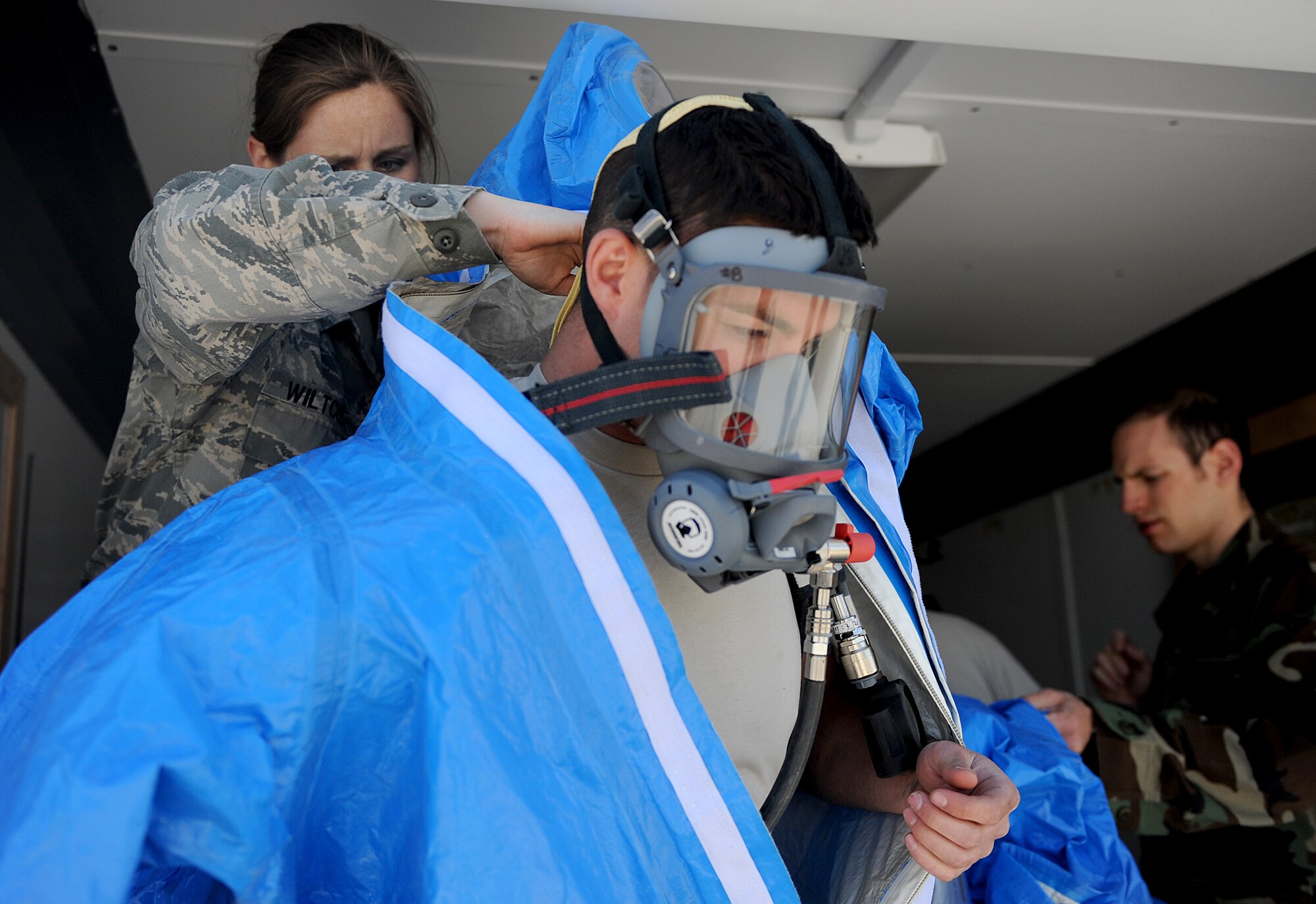 MOUNTAIN HOME AIR FORCE BASE, Idaho -- Staff Sgt. Jennifer Wiltcher, 366th Aerospace Medicine Squadron bioenvironmental engineer technician, assists Airman 1st Class Todd Kolva with donning the hazardous chemical protective suit prior to entering a possible contaminated area May 12. The bioenvironmental engineer flight is participating in the Air Combat Command chemical, biological, radiological, nuclear and high yield explosive (CBRNE) challenge, which consists of several scenarios they may encounter such as a suspicious package or chemical spill. The team will compete against other ACC bases and could then move on to compete at the Air Force level. (U.S. Air Force photo/ Senior Airman Ryan Crane)