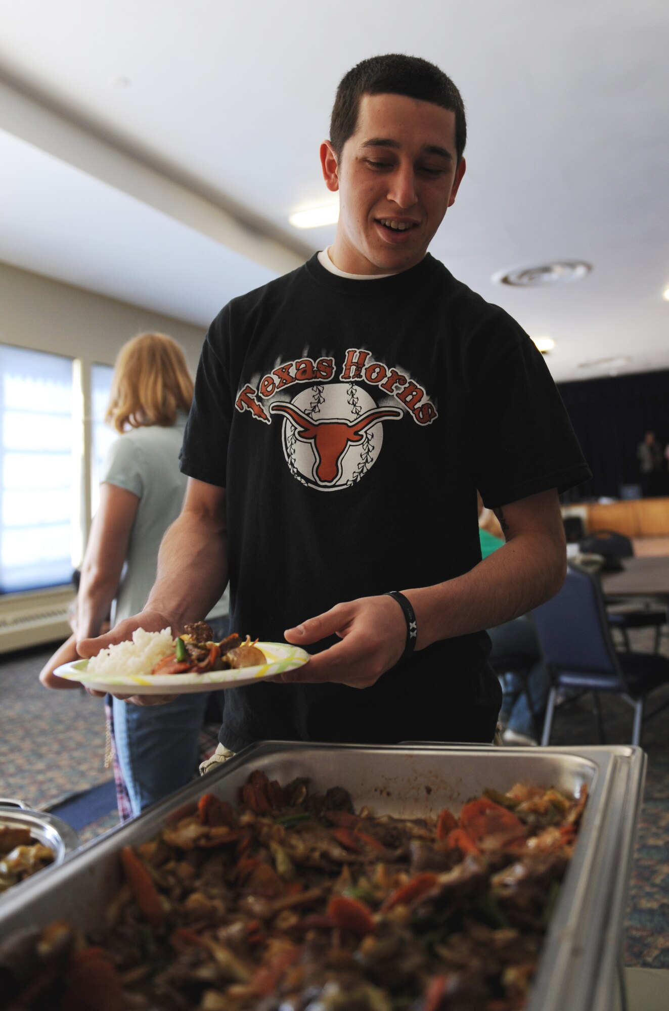 MOUNTAIN HOME AIR FORCE BASE, Idaho -- Airman Brandon Garcia, 366th Medical Group health service management, receives a free Asian-themed dinner at the community center May 16 during the Sights and Sounds of Asia and the Pacific Islands. The dinner was part of the month-long Asian- Pacific celebration. Each May, the base joins other installations and organizations across the nation to celebrate Asian Pacific American Heritage and honor the contributions these Americans made throughout U.S. history. (U.S. Air Force photo/ Airman 1st Class Renishia Richardson)