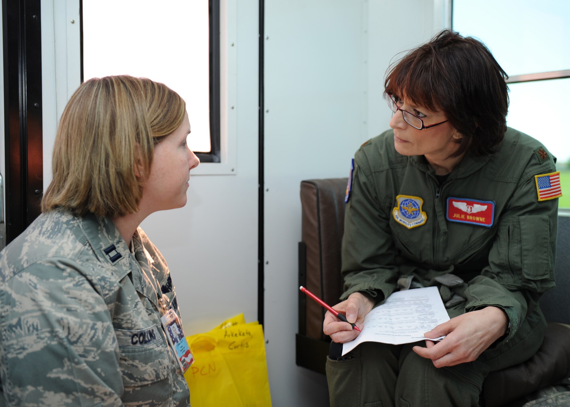 SCOTT AIR FORCE BASE, Ill. -- Capt. Joy Collins, 375th Aeromedical Staging Facility flight commander, transfers the nursing report to Maj. Julie Browne, 375th Aeromedical Evacuation Squadron's medical crew director for this flight, at Scott May 18. (U.S. Air Force photo/Staff Sgt. Paul Villanueva II)