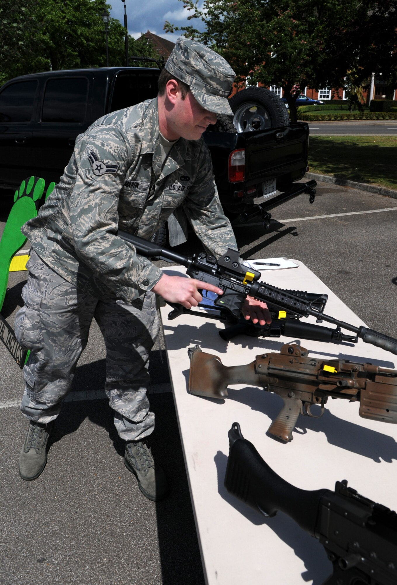 Airman 1st Class Breck Martin, 352nd Maintenance Squadron, checks out a gun on display from the 321st Special Tactics Squadron during a safety day demonstration at RAF Mildenhall’s Galaxy Club May 19.  (U.S. Air Force photo by Staff Sgt. Austin M. May)