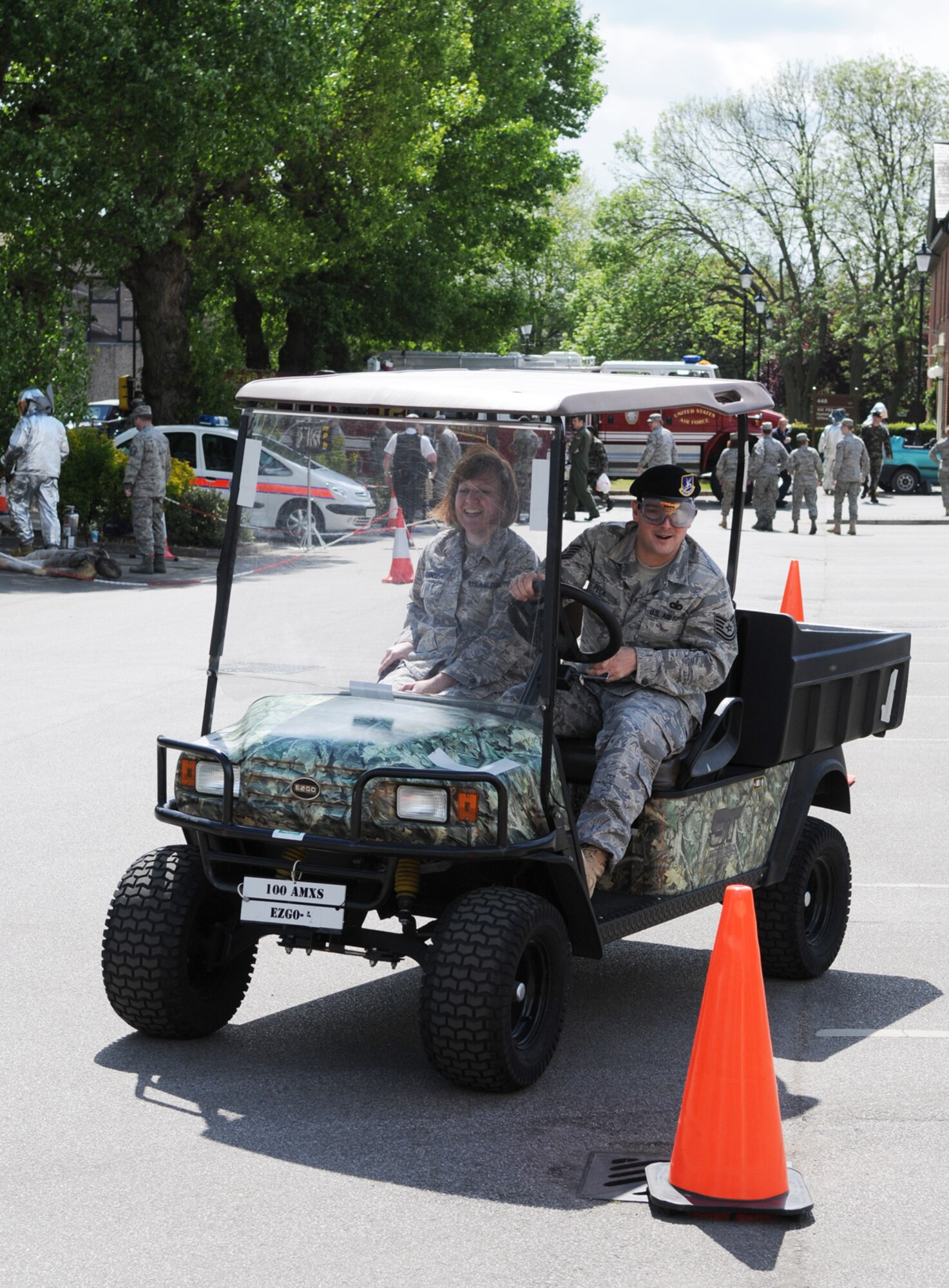 Tech. Sgt. Jason Peck, 100th Security Forces Squadron, drives a golf cart while wearing goggles designed to simulate the effects of drinking while Airman 1st Class Michelle Robinson, 48th Medical Support Squadron, acts as a safety spotter.  The simulation was part of a half-day event to highlight safety for the upcoming 101 Critical Days of Summer.  (U.S. Air Force photo by Staff Sgt. Austin M. May)