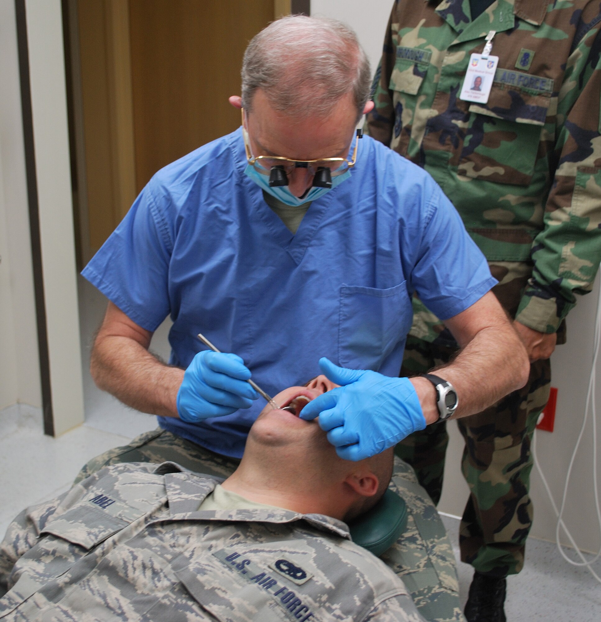 Col. William Byers, a dentist with the 476th Aerospace Medicine Flight, performs an exam on Staff Sgt. Brandon Abel.