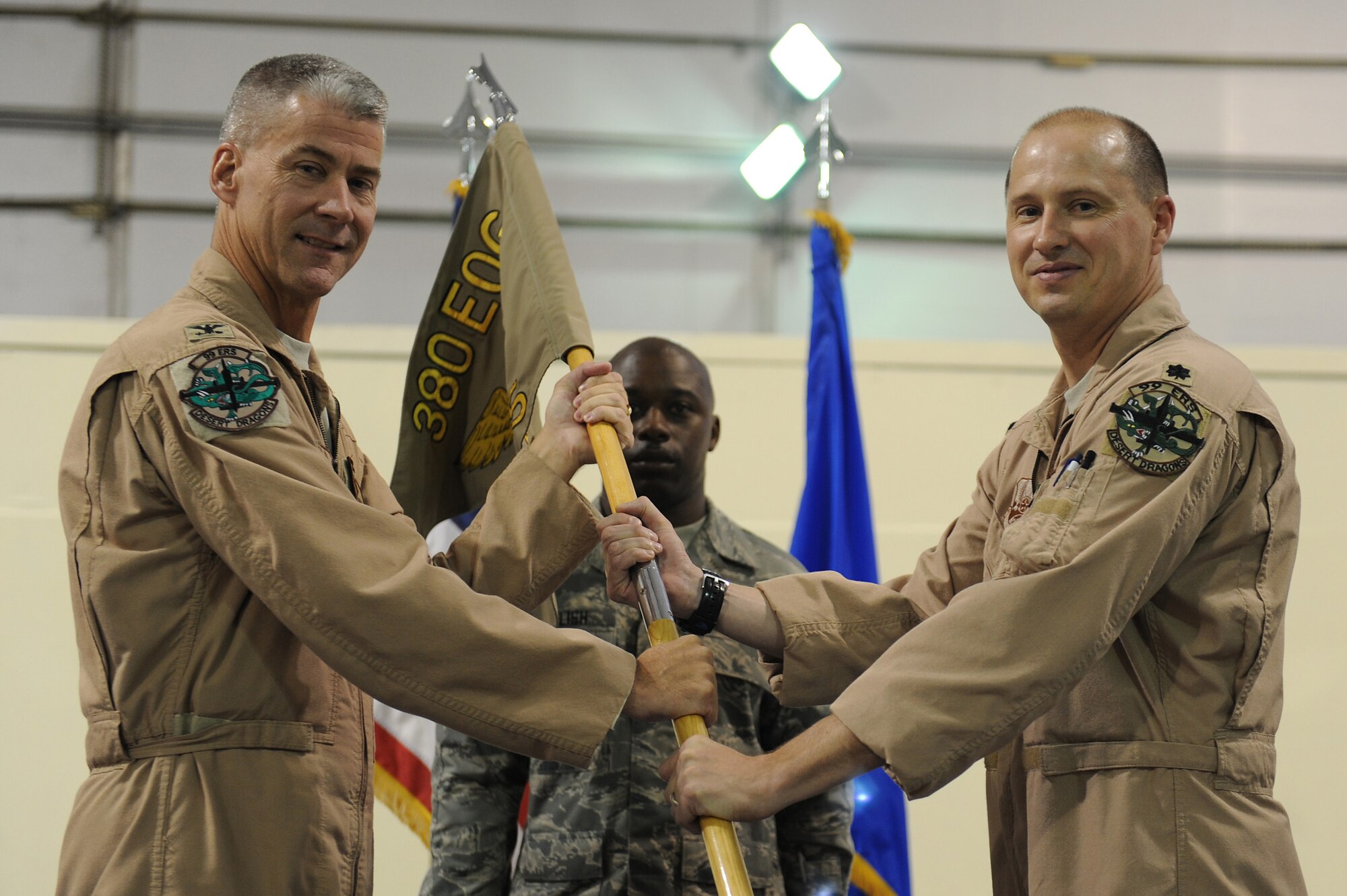 Col. Kyle Garland, 380th Expeditionary Operations Group, commander, passes the flag of the 99th Expeditionary Reconnaissance Squadron to Lt. Col. Kirt Stallings as he takes command, May 15 at an undisclosed location in Southwest Asia. Colonel Stallings comes from Beale AFB, Calif. to take over command of the 99th ERS. (U.S. Air Force photo by Senior Airman Brian J. Ellis) (Released)