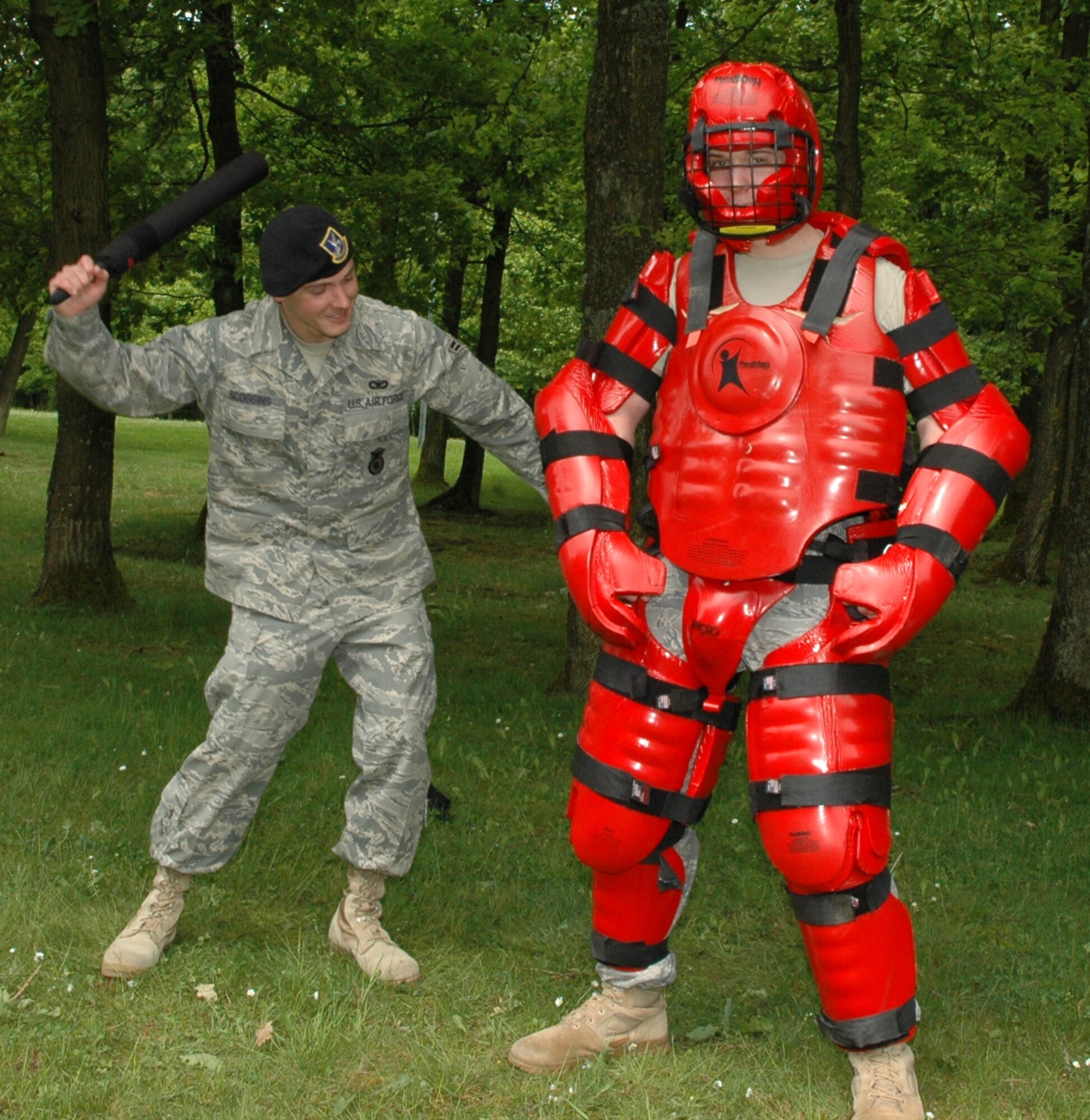 SPANGDAHLEM AIR BASE, Germany -- Airman 1st Class Joshua Scoggins, 52nd Security Forces Squadron, whacks fellow 52nd SFS member, Airman 1st Class Maxx Hauer, May 13, 2009, demonstrating the use of “The Red Man Suit,” a protective suit used for training purposes. The Airmen, along with other 52nd SFS members, visited Spangdahlem Elementary and Middle Schools May 12-13, respectively, in support of Police Week. (Photo by Bobbie Gonzales)