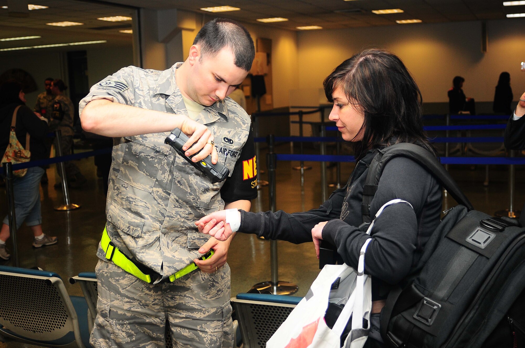 YOKOTA AIR BASE, Japan -- Staff Sgt. Scot Riddell, non combatant tracking system operator, scans Sarah Bleistein's identification bracelet May 15 during a semi-annual noncombatant evacuation operations exercise, Courageous Channel. The exercise tested the command's NEO plans and procedures for a short-notice evacuation of non-combatants. (U.S. Air Force photo/Airman Sean Martin)