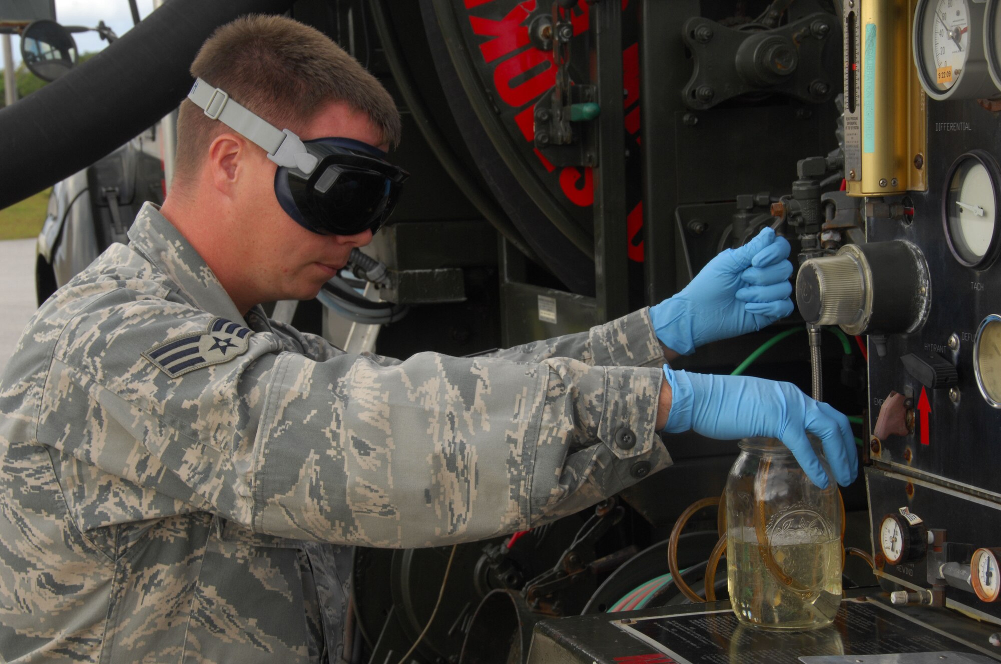 ANDERSEN AIR FORCE BASE, Guam - Senior Airman Ben English, 36th Logistics Readiness Squadron Petroleum, Oil and Lubricants flight fuels laboratory technician, drains fuel from an R-12 refueling truck May 20. The fuels laboratory samples all fuel numerous times before it is used. (U.S. Air Force photo by Senior Airman Shane Dunaway)
