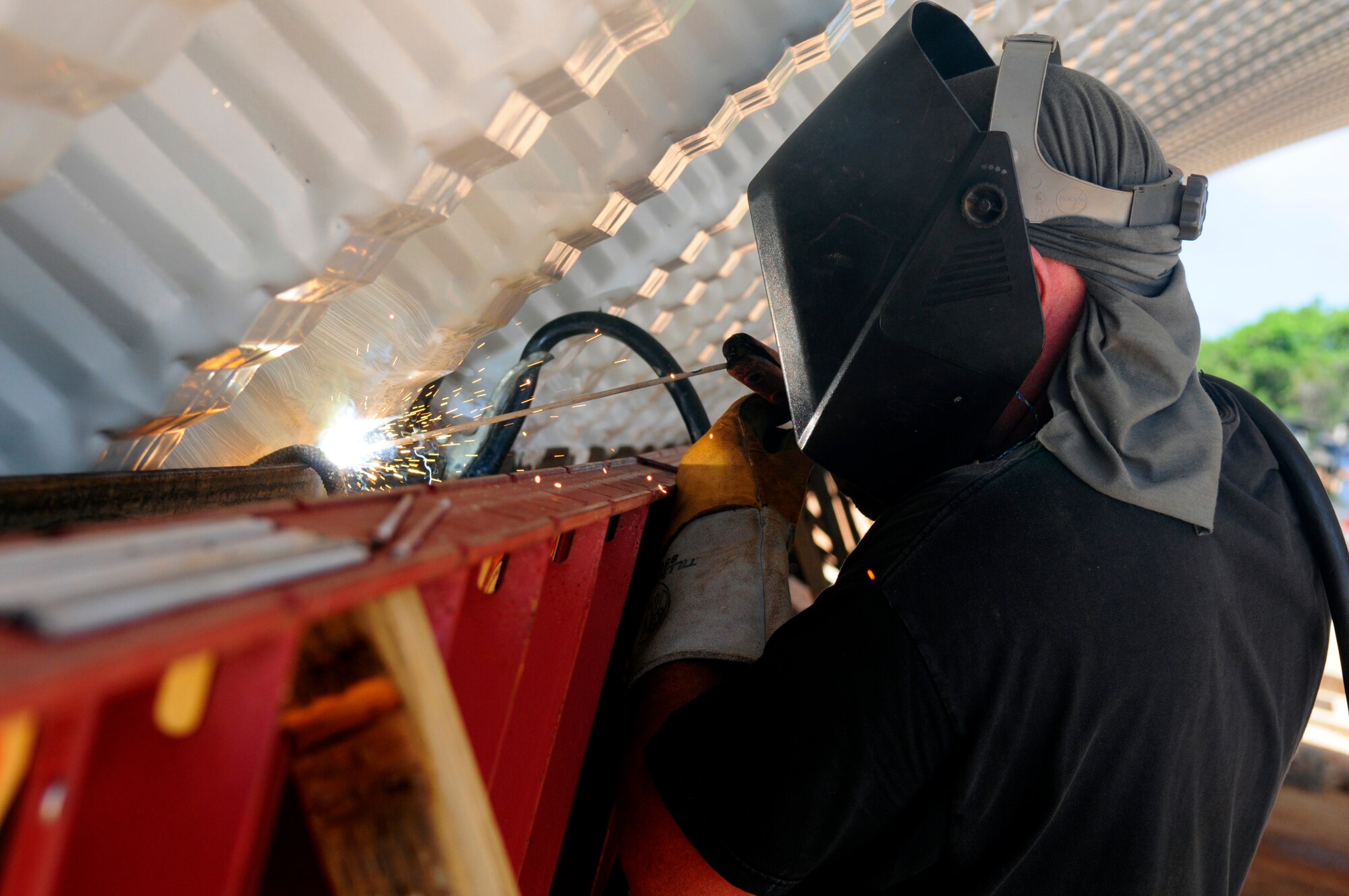 ANDERSEN AIR FORCE BASE, Guam - Master Sgt. Delbert Zehrung, 144th Air National Guard Civil Engineer Squadron noncomissioned officer in charge of Power Production, welds the bottom of the arc to hold in place as the final touch before completion of the k-span at Northwest Field May 13. The 144th ANG CES are here for two weeks to help with the k-span building that will continue till August 1. (U.S. Air Force photo by Airman 1st Class Courtney Witt)

