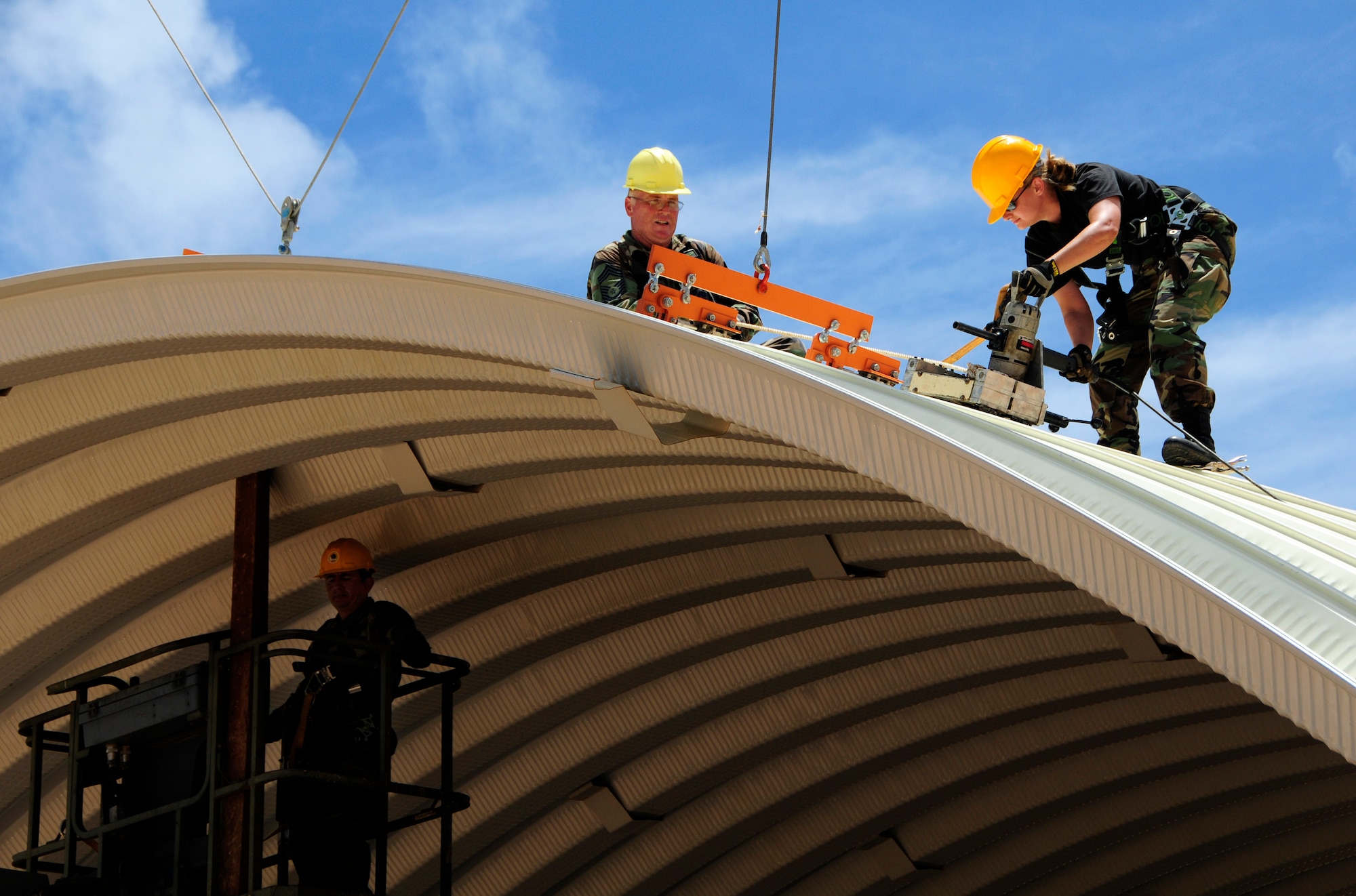 ANDERSEN AIR FORCE BASE, Guam - (From right) Staff Sgt. Nichola Peacock and Chief Master Sgt. Michael Scott seam together the last bit of the k-span roof at Northwest Field May 13. The 144th ANG CES are here for two weeks to help with the k-span building that will continue till August 1. (U.S. Air Force photo by Airman 1st Class Courtney Witt)

