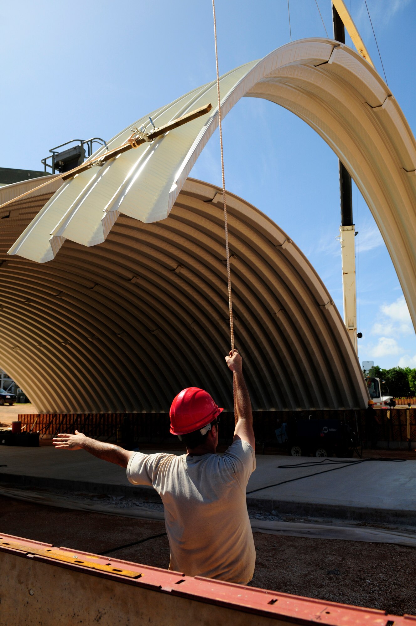 ANDERSEN AIR FORCE BASE, Guam - Tech Sgt. Kristopher Jones, 554th Rapid Engineer Deployable Heavy Operational Repair Squadron Engineer, helps guide the crane into place at Northwest Field May 13 as they finish with the second k-span.  The k-span building that will continue till August 1. (U.S. Air Force photo by Airman 1st Class Courtney Witt)
