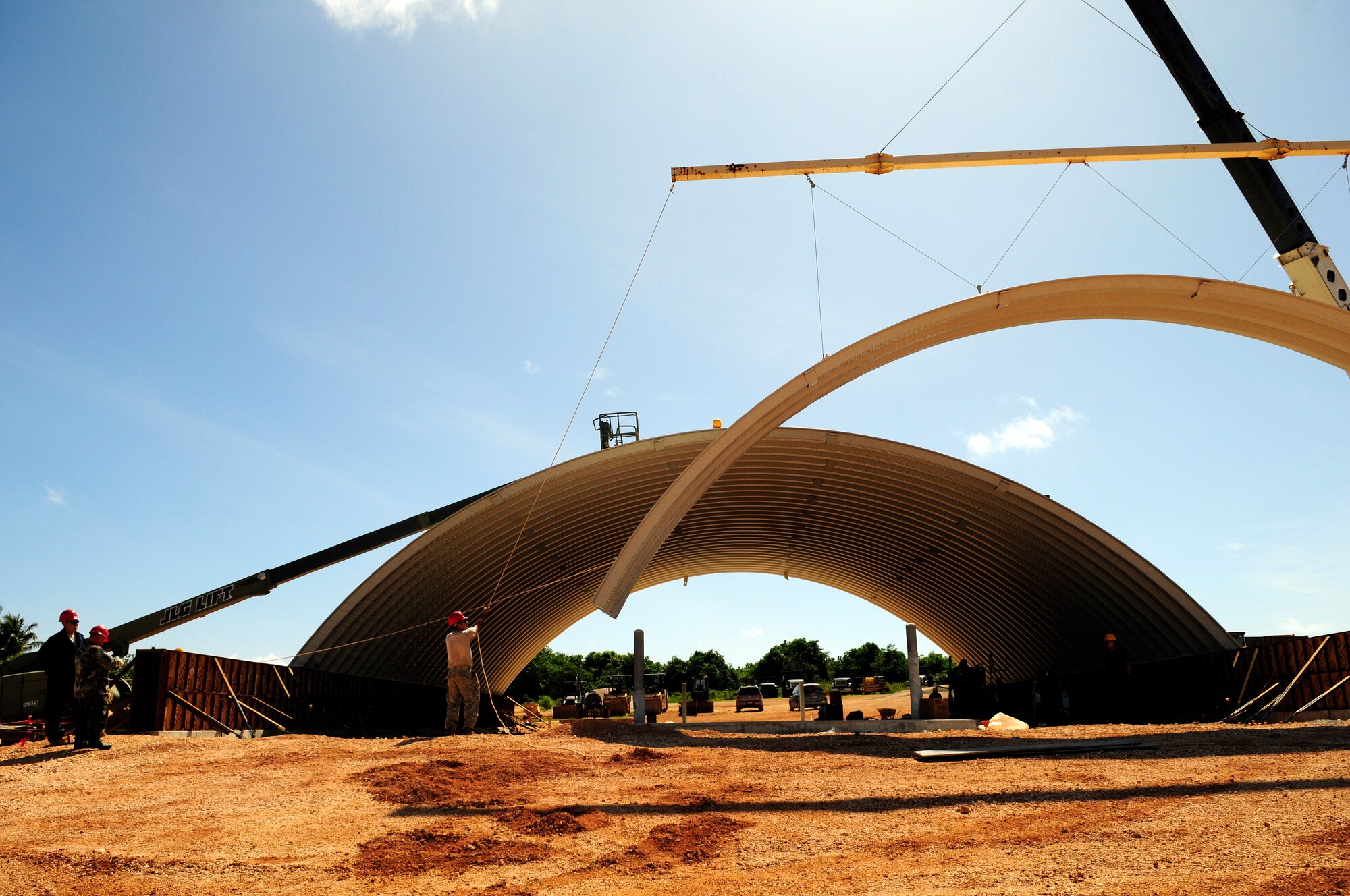 ANDERSEN AIR FORCE BASE, Guam - Members from the 144th Air National Guard Civil Engineer Squadron and the 554th Rapid Engineer Deployable Heavy Operational Repair Squadron Engineer helps guide the crane that lifts 1,500 pounds of steel to finish the final section of the k-span roof at Northwest Field May 13.The 144th ANG CES are here for two weeks to help with the k-span building that will continue till August 1. (U.S. Air Force photo by Airman 1st Class Courtney Witt)
