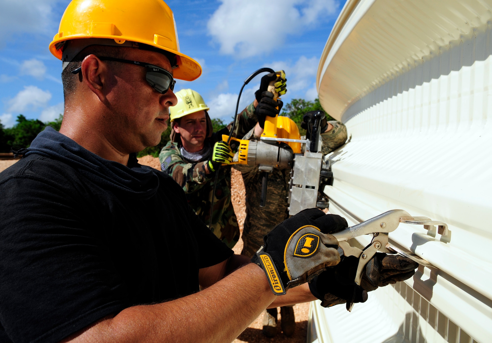 ANDERSEN AIR FORCE BASE, Guam - Staff Sgt. Jose Jimenez-Garcia removes a clamp while Staff Sgt. Joseph Ross and Staff Sgt. Arthur Laubach seam two steel arcs together at Northwest Field May 13. The three individuals are from the 144th Air National Guard Civil Engineer Squadron that are here for two weeks to help with the k-span building that will continue till August 1. (U.S. Air Force photo by Airman 1st Class Courtney Witt)
