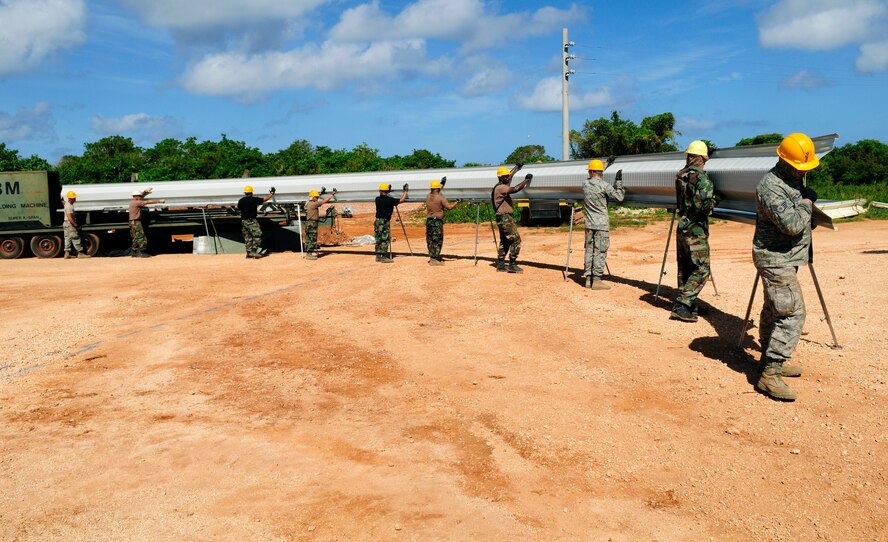 ANDERSEN AIR FORCE BASE, Guam - The 144th Air National Guard Civil Engineer Squadron help pull 500-pounds of steel out of the Automatic Building Machine 240 after shaping in into an arc at Northwest Field May 13. The 144th ANG CES are here for two weeks to help with the k-span building that will continue till August 1. (U.S. Air Force photo by Airman 1st Class Courtney Witt)
