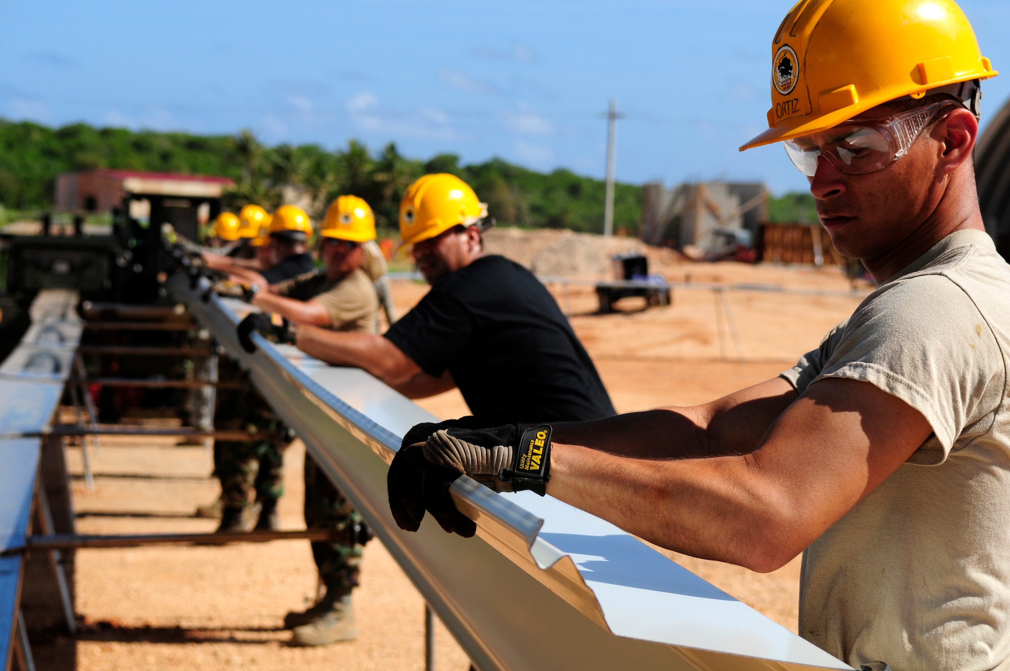 ANDERSEN AIR FORCE BASE, Guam - Airman 1st Class Roberto Ortiz, 144th Air National Guard Civil Engineer Squadron engineering assistant, and his team push a 500-pound piece of steel into a Automatic Building Machine 240 at Northwest Field May 13. The 144th ANG CES are here for two weeks to help construct the k-span building.  Construction will continue until Aug.1. (U.S. Air Force photo by Airman 1st Class Courtney Witt)