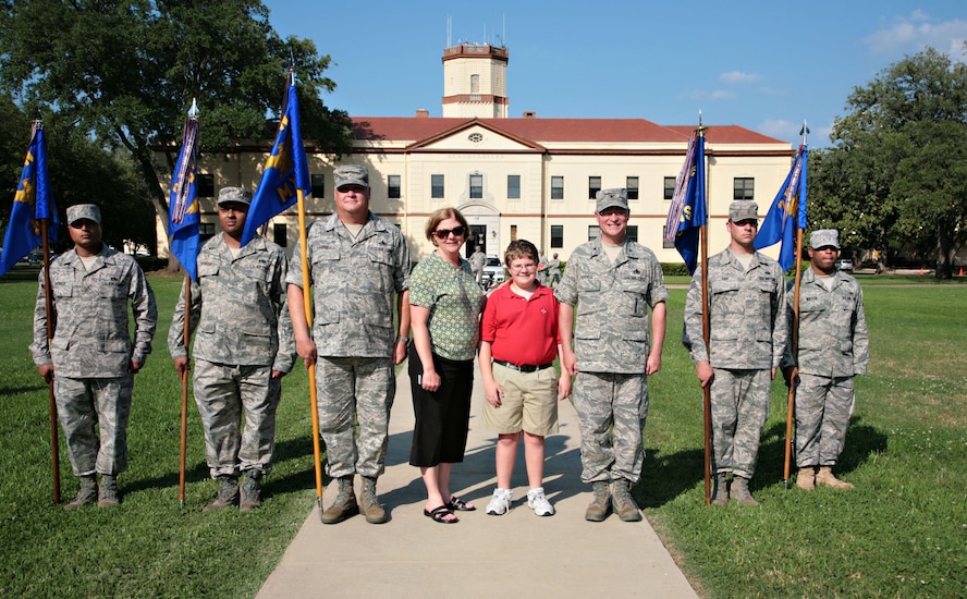 Caela, Luke and Col. Steven Shinkle take a final photo in front of the 2d Bomb Wing Headquarters building prior to his retirement. Colonel Shinkle, 2d Maintenance Group commander, will retire from the Air Force Aug. 1 after 32 years of service to the United States of America. His change of command and retirement ceremony is scheduled to be held June 2. (U.S. Air Force photo/Senior Master Sgt. Mahmoud Rasouliyan)