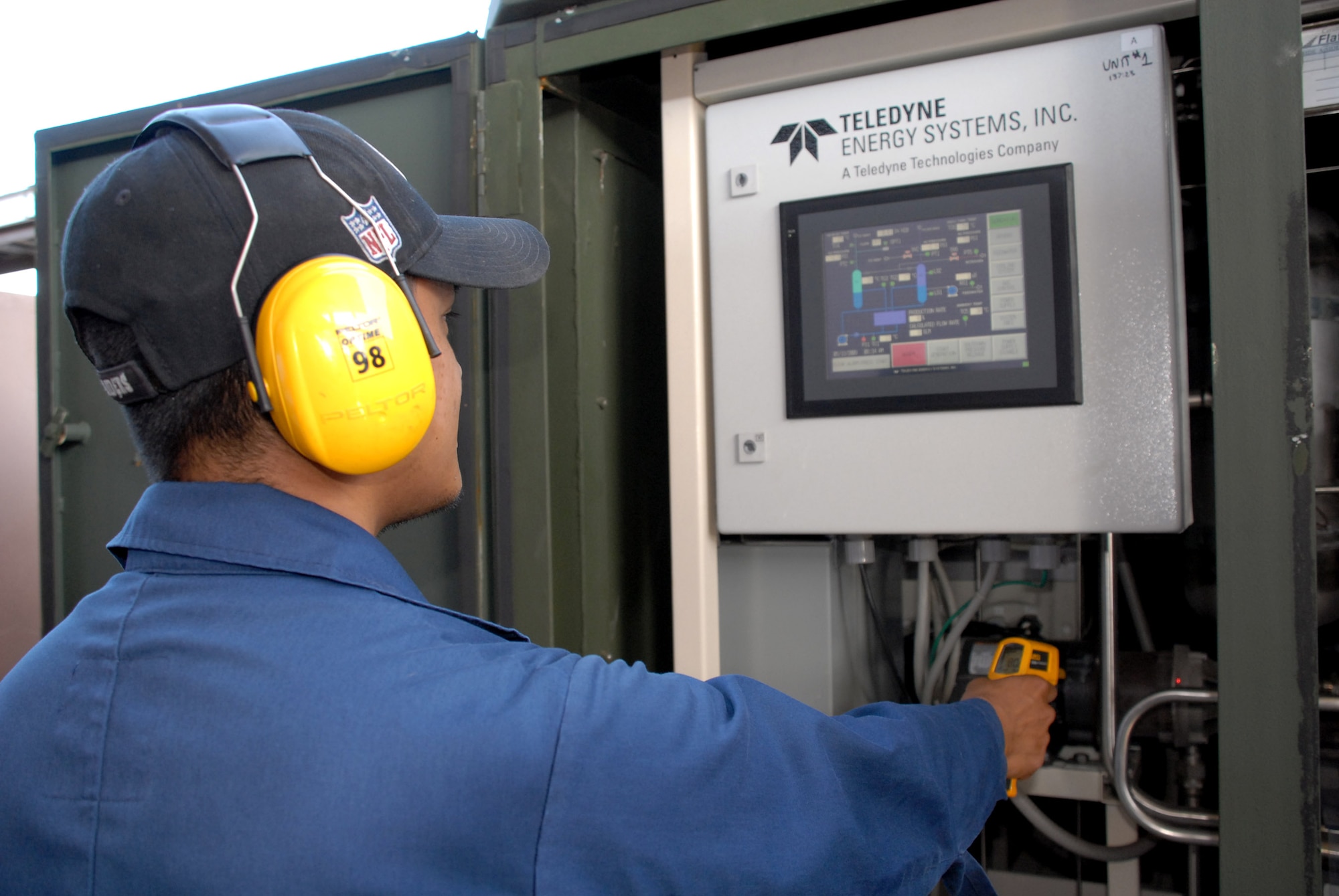 Chris Gaje checks the temperature on an electrolyzer at Hickam Air Force Base, Hawaii, May 13. The electrolyzer uses water (H2O) and electricity from the inverter box to flash boil water so hot and so fast that the hydrogen and oxygen atoms in the water split to make pure hydrogen. The hydrogen provides non-petroleum-based power for vehicles The first hydrogen-powered vehicle here was developed in 2003, and because the hydrogen plant is now powered by the solar array they have achieved a major demonstration milestone in the program. (U.S. Air Force photo/Senior Airman Carolyn Viss)