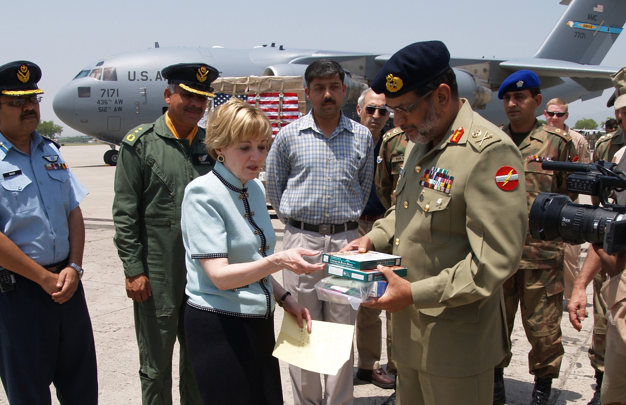 U.S. Ambassador to Pakistan Anne W. Patterson hands over one of the 120,000 meals destined for displaced people in Pakistan to Lt. Gen. Nadeem Ahmed, coordinator of Pakistan's relief effort at Chaklala Air Base, Pakistan, May 20. (U.S. State Department photo) 
  