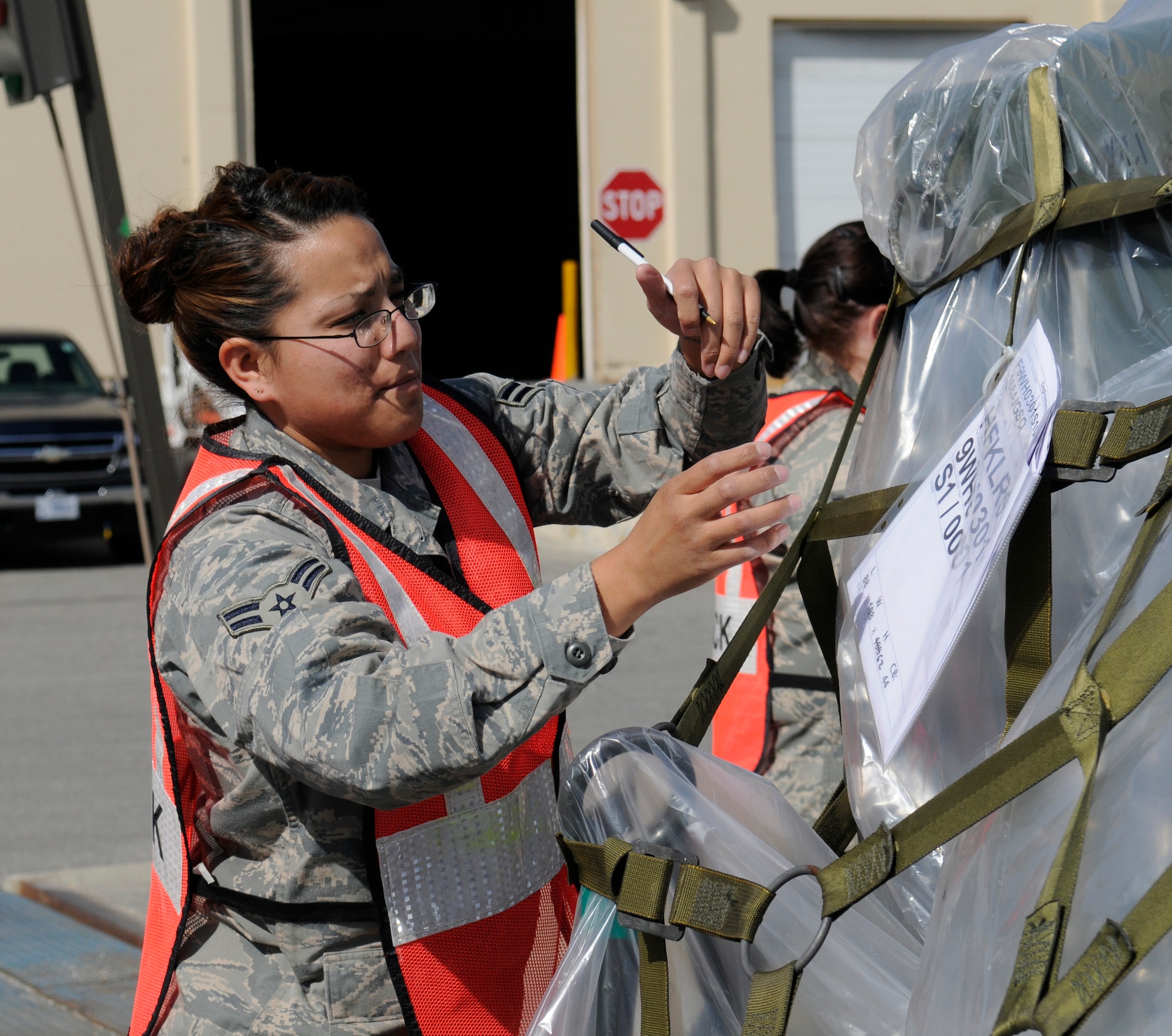 Airman 1st Class Catherine Melendrez reaches for a packing list during a cargo inspection May 18, 2009, Eielson Air Force Base, Alaska. The cargo supplies will be loaded onto a plane as part of an operational readiness exercise tasking.  Airman Melendrez is assigned to the 354th Logistics Readiness Squadron Traffic Management office. (U.S.  Air Force photo/Airman 1st Class Laura Max)