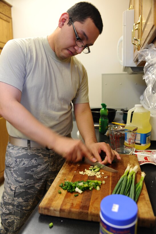 Senior Airman Gilberto Martinez, Air Force Financial Services Center station gained auditor, cuts a Serrano pepper during a Pad Thai cooking class at the Freedom Chapel here, May 19. Airman Martinez taught 14 people how to make Pad Thai, a dish from Thailand, along with a few tips on how to make it taste spicy. (U.S. Air Force photo/Senior Airman Kasey Zickmund)