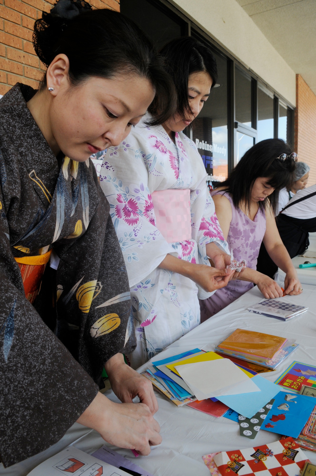 Megumi Bourns, Teruyo Mukai and Tamako Harris fold paper into animal shapes to demonstrate the art of origami at the Asian Pacific American Heritage Cultural Fair at Robins May 15. U. S. Air Force photo by Sue Sapp