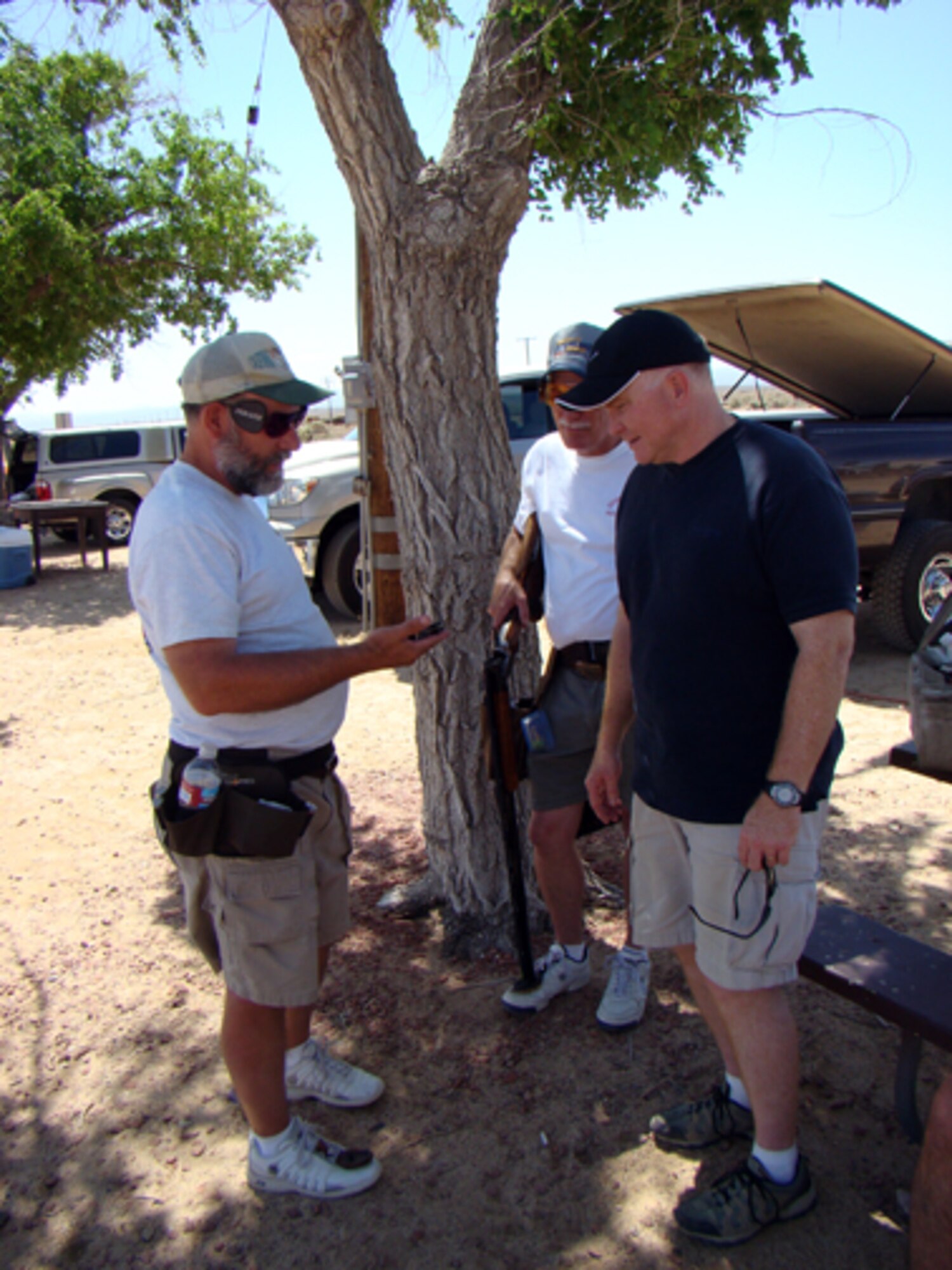 Bruce Hobbs (left), 95th communications Group deputy chief information support chief, explains a competition shot gun trigger to Col. Jerry Gandy (middle), 95th Air Base Wing commander, as Jim Neal, volunteer, looks on during the Winter Chain Trap Shooting competition May 16 and 17. (Courtesy photo)