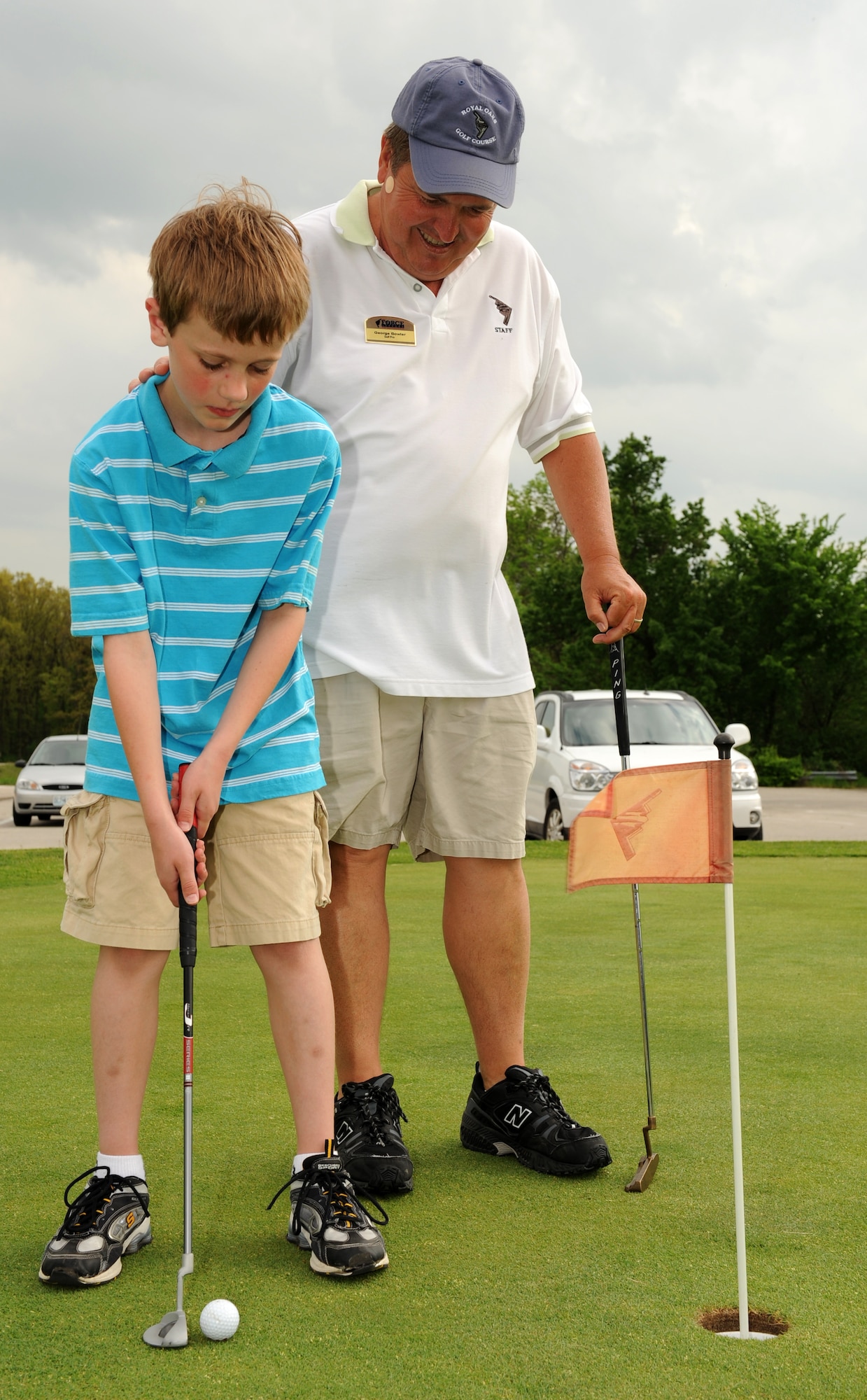 WHITEMAN AIR FORCE BASE, Mo. - Tad, a local youth, receives putting instructions from George Bowlar, class instructor, at the Royal Oaks Golf Course practice putting green May 13. Tad participated in youth golf classes held by the 509th Force Support Squadron. (U.S. Air Force photo/Staff Sgt. Charles Larkin)  