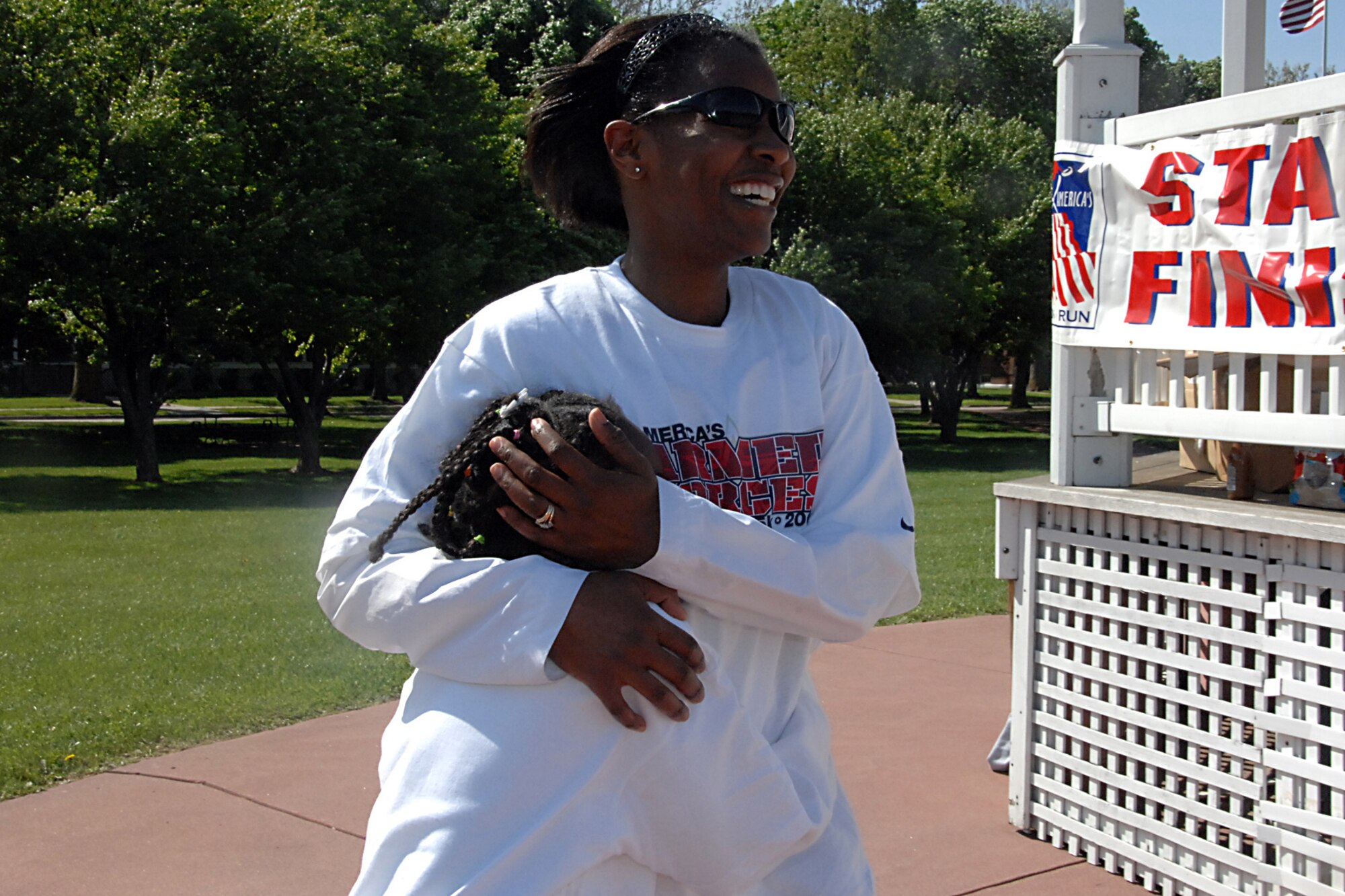 Offutt Air Force Base, Neb. -- Master Sgt. Tomeika Elmore, 55th Strategic Communications Squadron, congratulates her daughter Kayla Elmore, as she finishes the one-mile race during America's Armed Forces Kids Run at the parade grounds here May 16. America's Kids Run is an event that promotes fitness, while providing a safe and fun activity for military children. Run participants received a t-shirt, water bottle and jump rope. U.S. Air Force photo by Kendra Williams