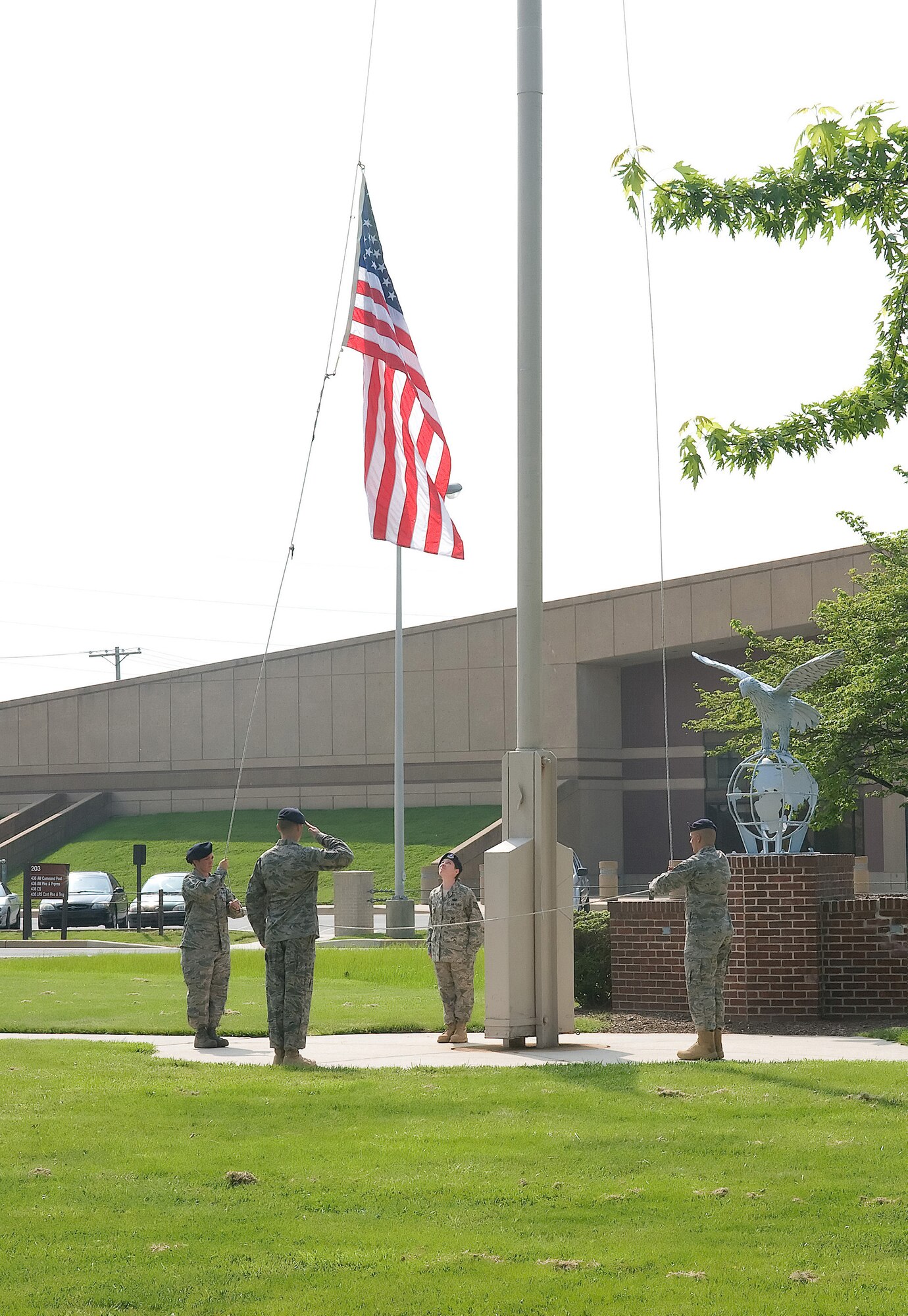 Tech. Sgt. Dwayne Pyle salutes as Senior Airmen Chelsey Olds and Richard Maricle lower the flag and Staff Sgt. Kimberly Nadeau prepares to catch the flag to prevent it from touching the ground during a retreat ceremony at Dover Air Force Base May 15. The 436th Security Forces Squadron performed the retreat ceremony as part of National Police Week, which honors those in the law enforcement profession who have made the ultimate sacrifice. (U.S. Air Force photo/Tom Randle)