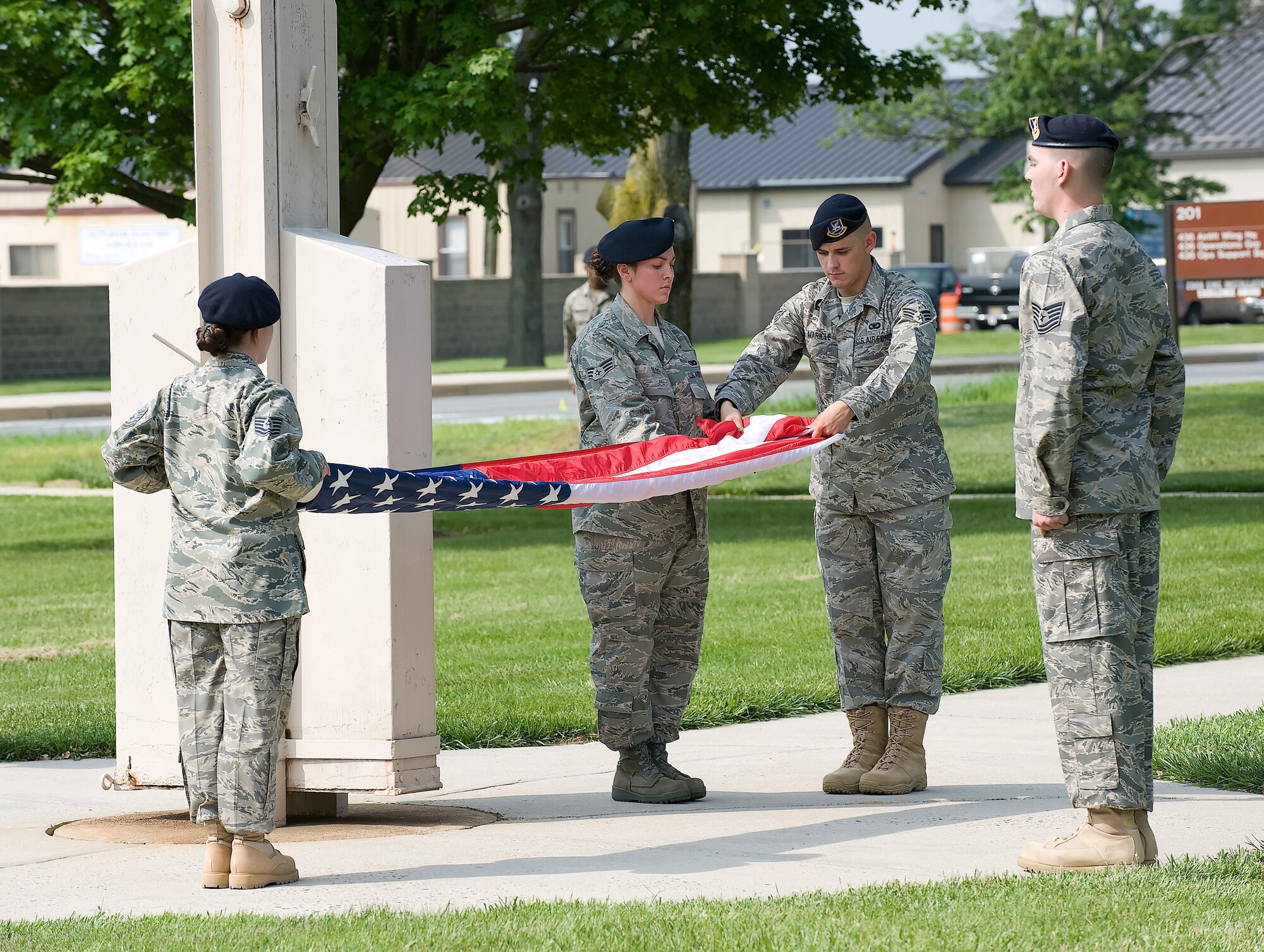 (From left) Staff Sgt. Kimberly Nadeau, Senior Airman Chelsey Olds and Senior Airman Richard Maricle, fold the American flag while Tech. Sgt. Dwayne Pyle observes during a retreat ceremony at Dover Air Force Base May 15. The 436th Security Forces Squadron performed the retreat ceremony as part of National Police Week, which honors those in the law enforcement profession who have made the ultimate sacrifice. (U.S. Air Force photo/Jason Minto)