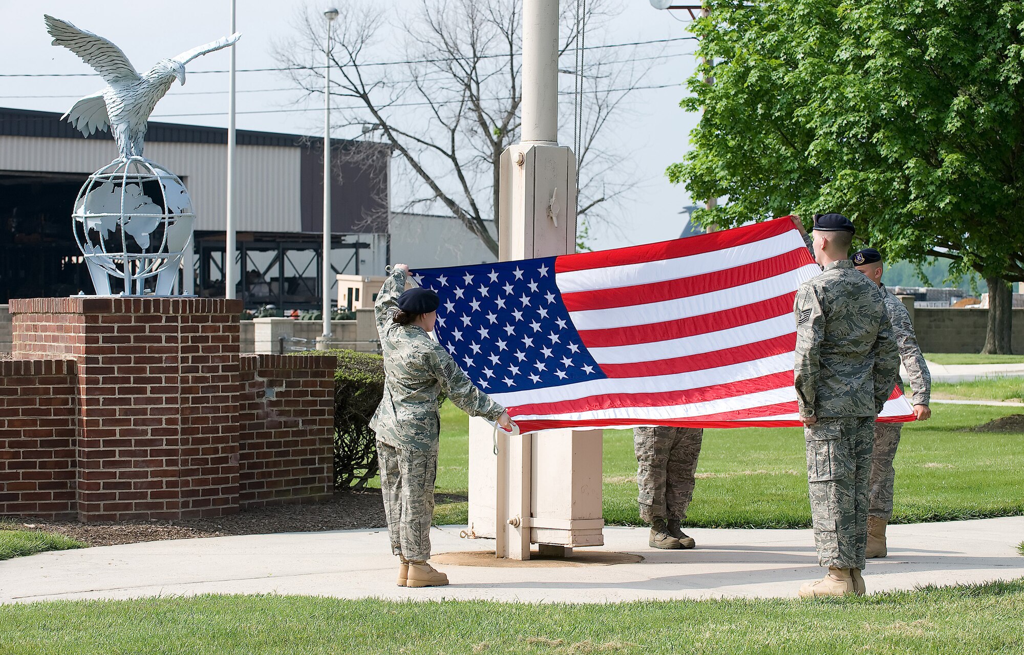 Staff Sgt. Kimberly Nadeau and Senior Airman Richard Maricle, fold the American flag while Tech. Sgt. Dwayne Pyle observes a retreat ceremony at Dover Air Force Base May 15. The 436th Security Forces Squadron performed the retreat ceremony as part of National Police Week, which honors those in the law enforcement profession who have made the ultimate sacrifice. (U.S. Air Force photo/Jason Minto)